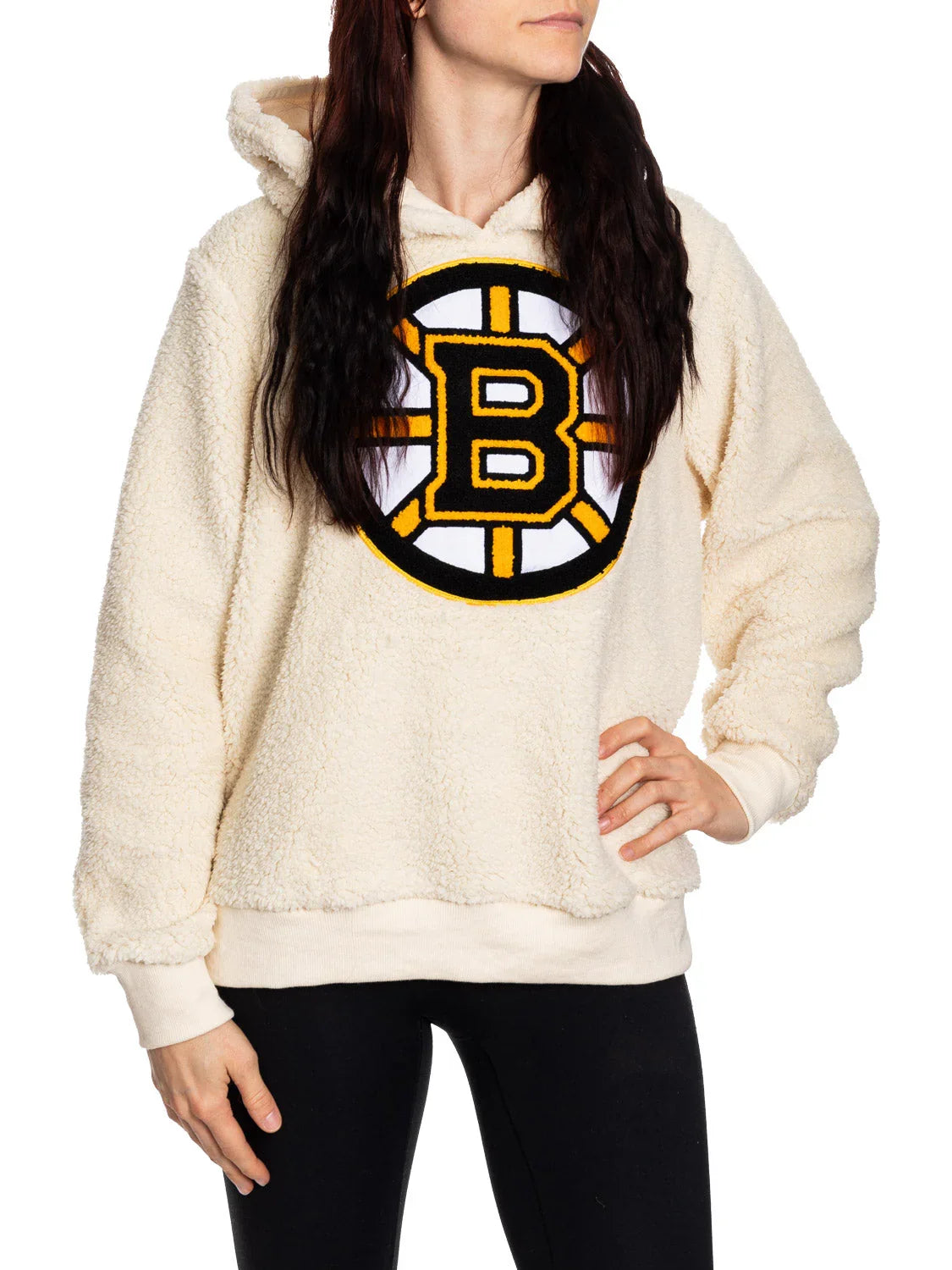 Woman wearing cream Boston Bruins sherpa hoodie with logo, standing against white background