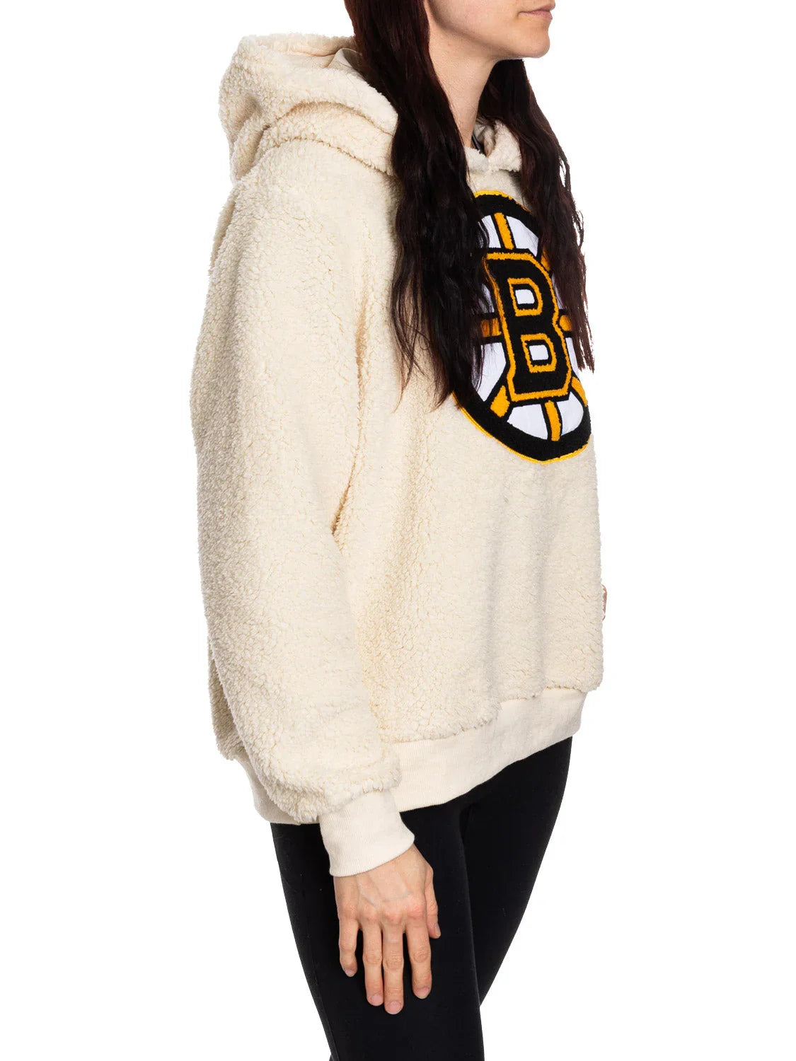 Woman in cream Boston Bruins sherpa hoodie with side profile, black leggings