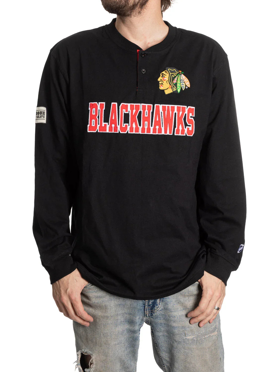 Man wearing black Chicago Blackhawks henley shirt with logo and distressed jeans