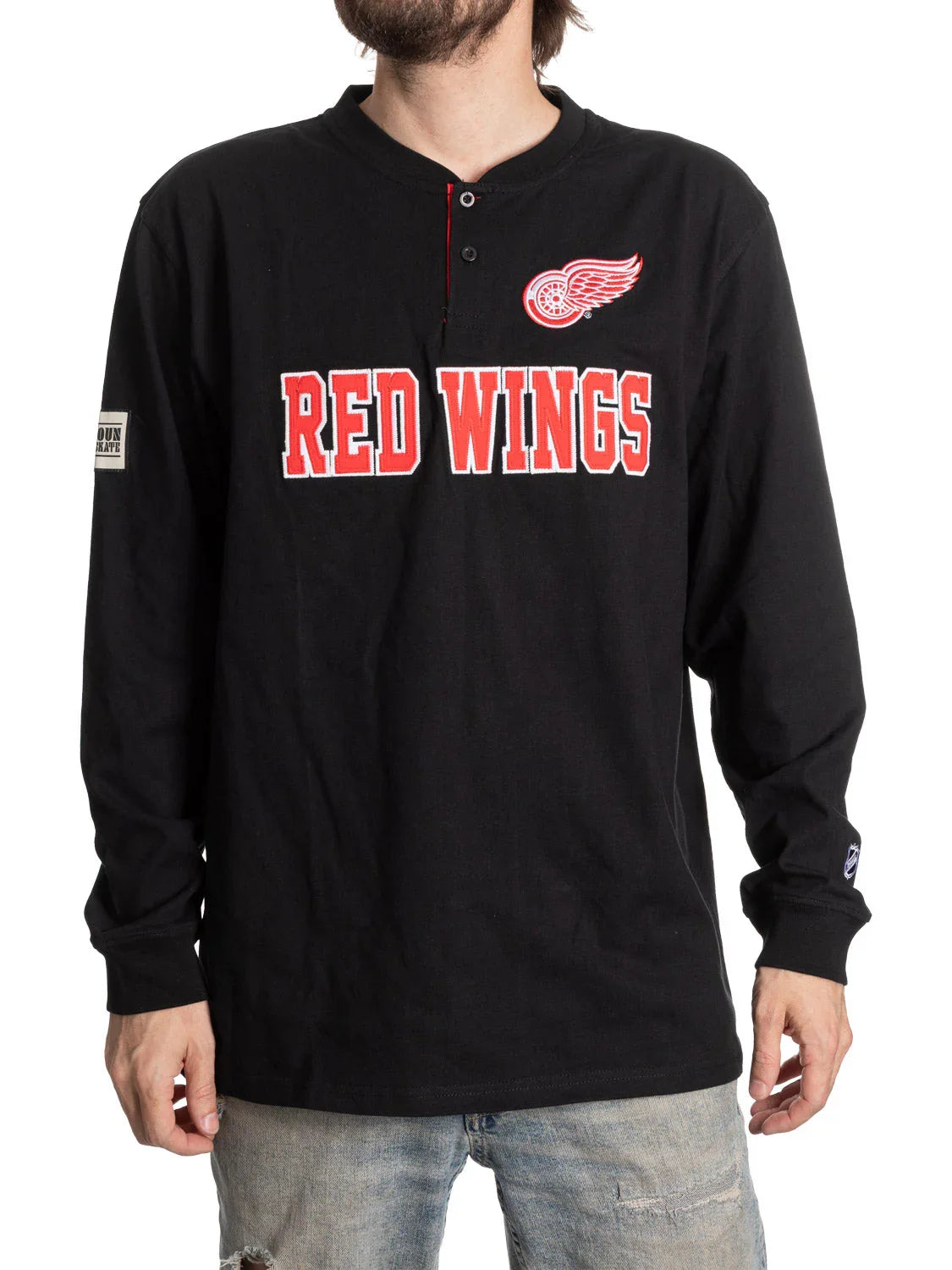 Man wearing black Detroit Red Wings henley shirt with red logo and jeans