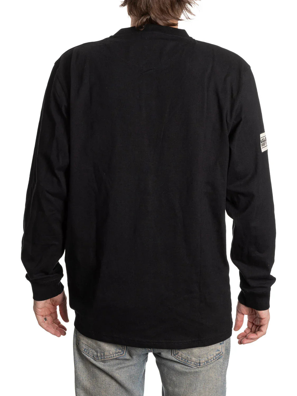 Back view of person in black long-sleeve Henley shirt and light blue jeans