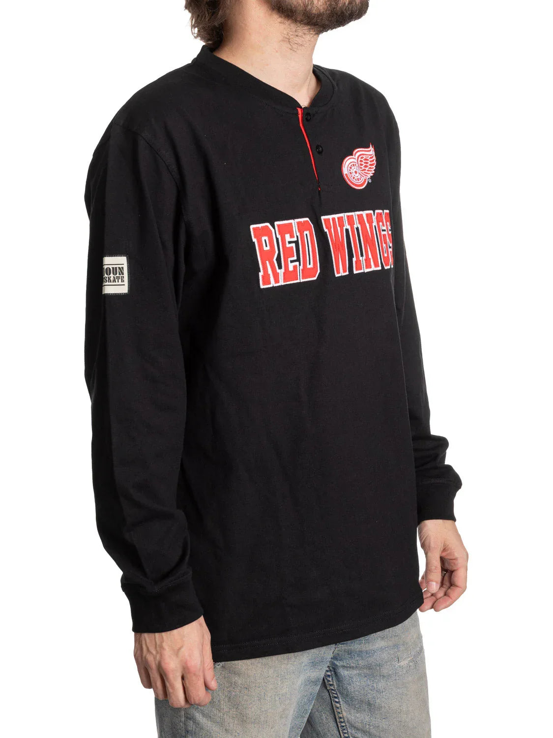 Man wearing black long sleeve Detroit Red Wings Henley shirt with logo and red lettering