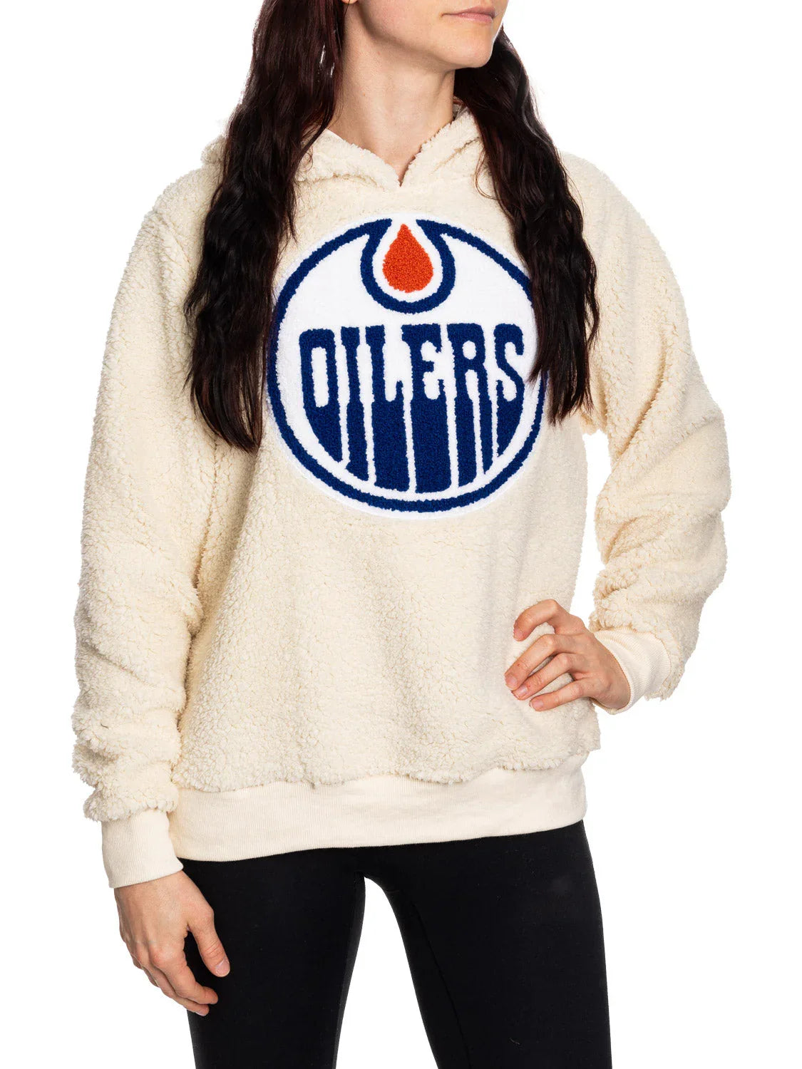 Woman wearing cream sherpa hoodie with large Edmonton Oilers logo on front