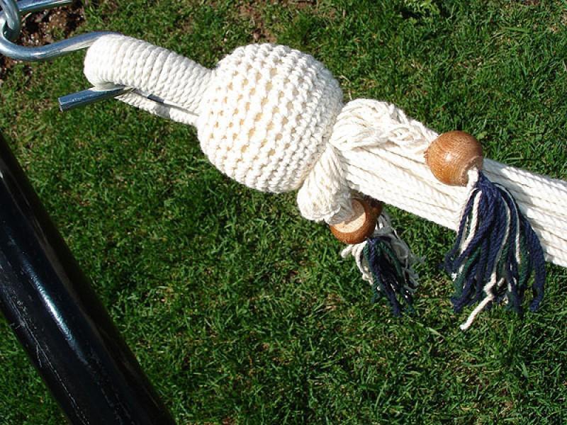 Nicaraguan fringed hammock rope with wooden beads and colorful tassels on green grass