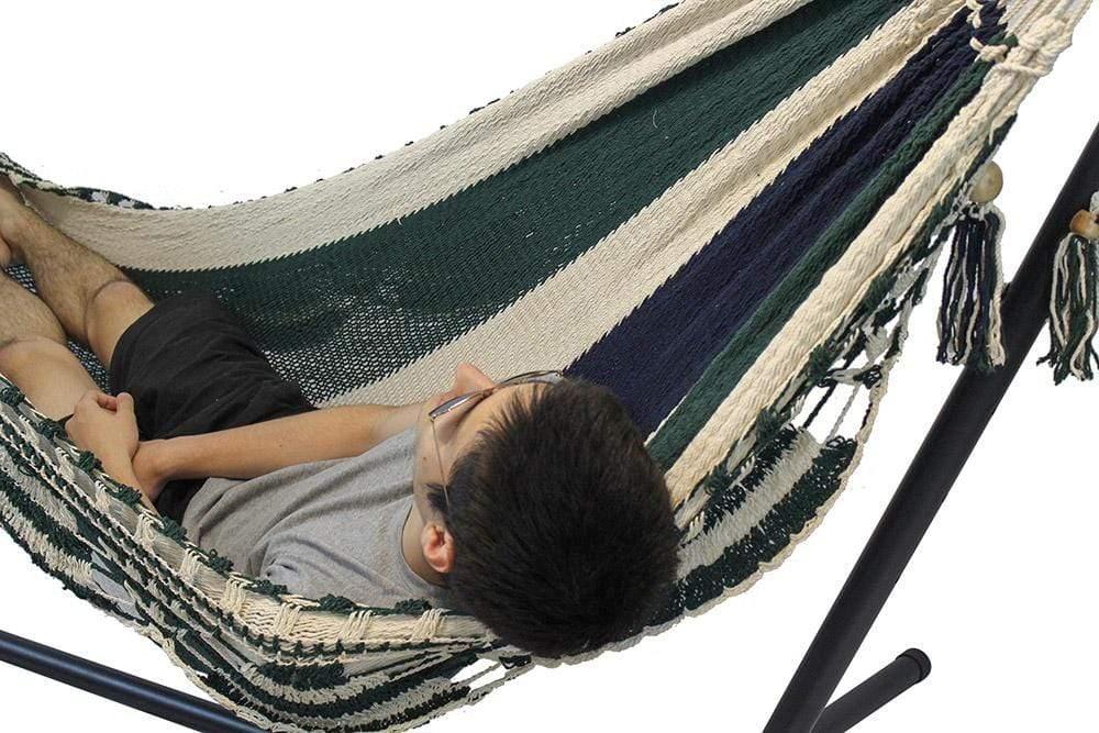 Man relaxing in a striped Nicaraguan hammock on a universal stand