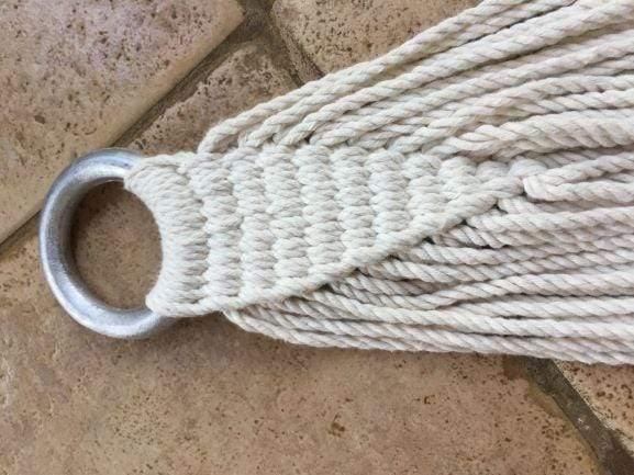 Close-up of a hammock rope loop with metal ring on tile floor