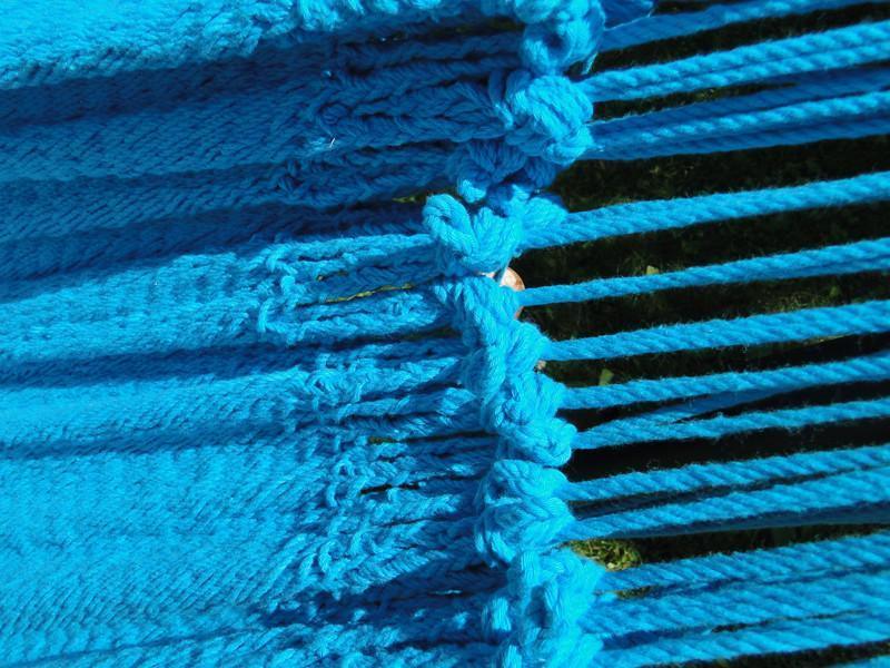 Close-up of bright blue woven hammock strings outdoors