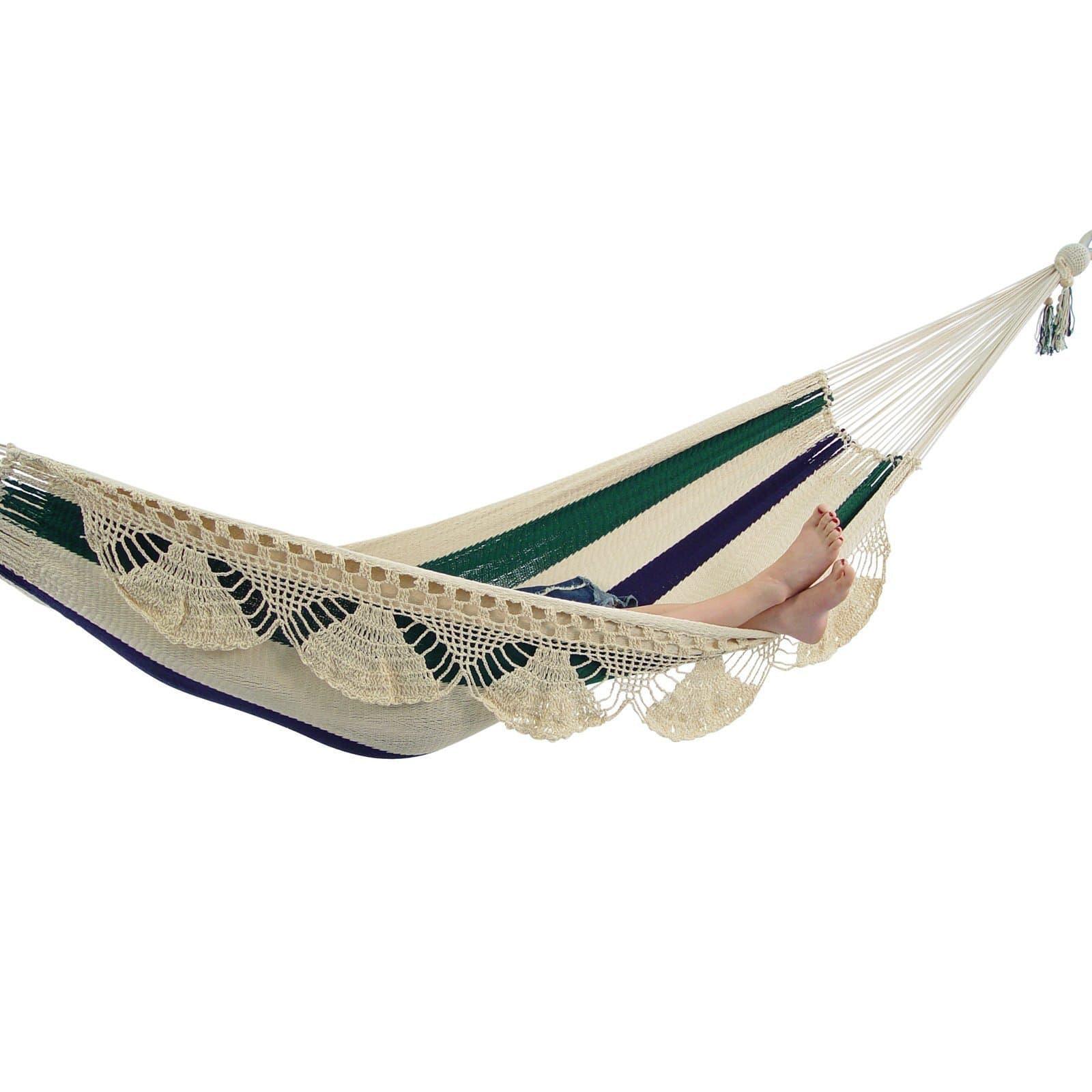Handwoven Nicaragua hammock with cream, green, and navy stripes, lace fringe, and feet visible
