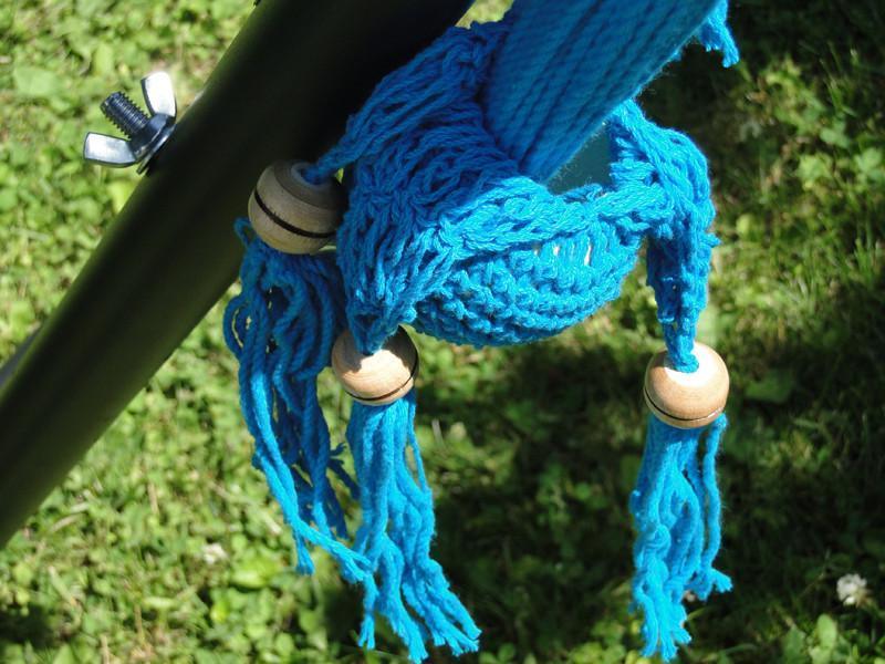 Blue macrame swing chair rope detail with wooden beads on metal frame outdoors