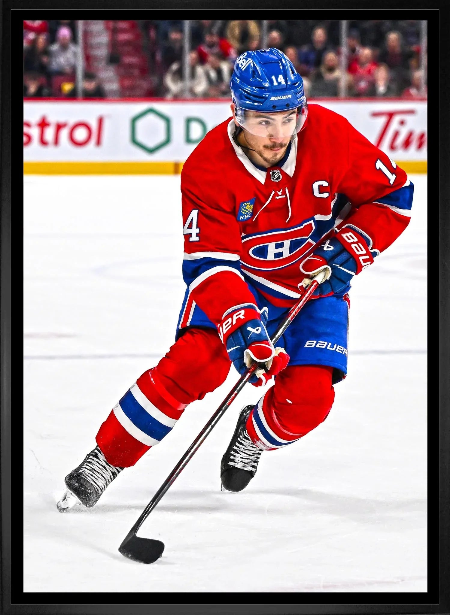 Montreal Canadiens hockey player in red jersey skating on ice with stick and puck