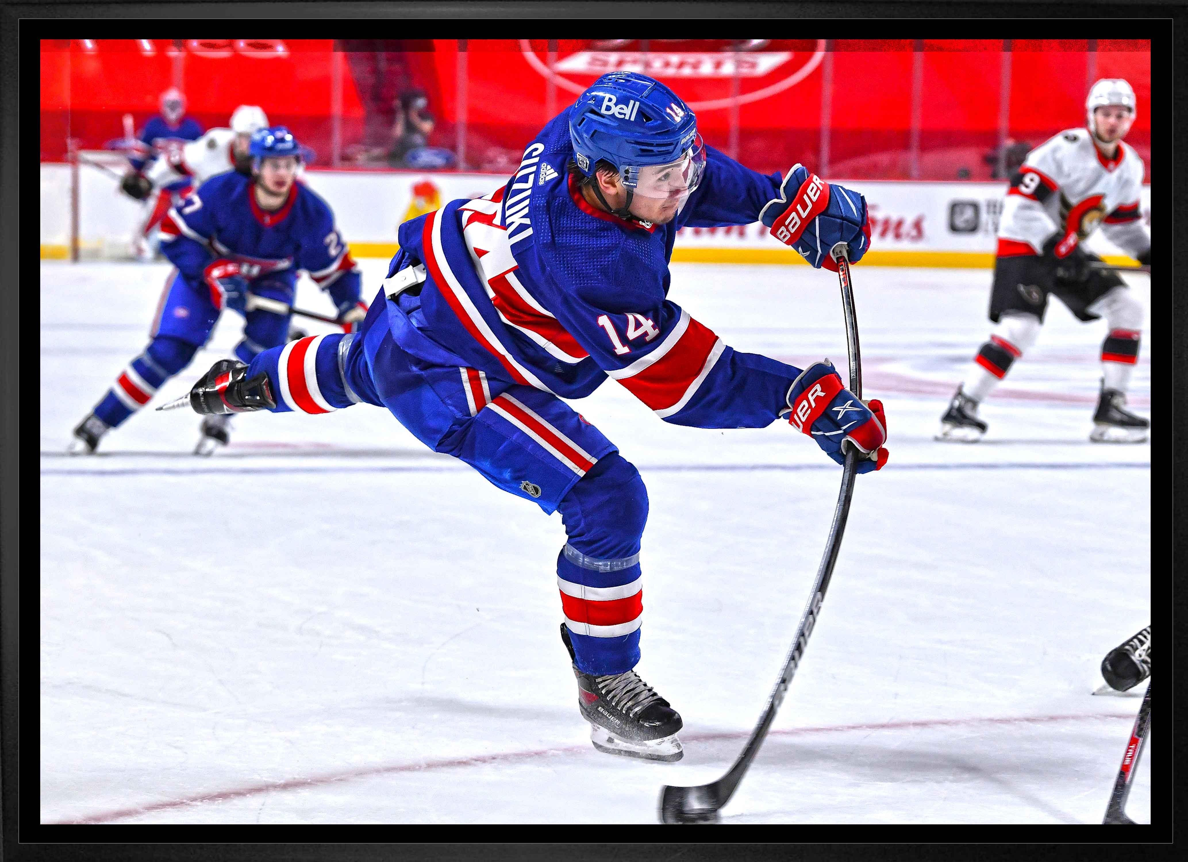 Ice hockey player in blue jersey taking a powerful shot during a game on the rink