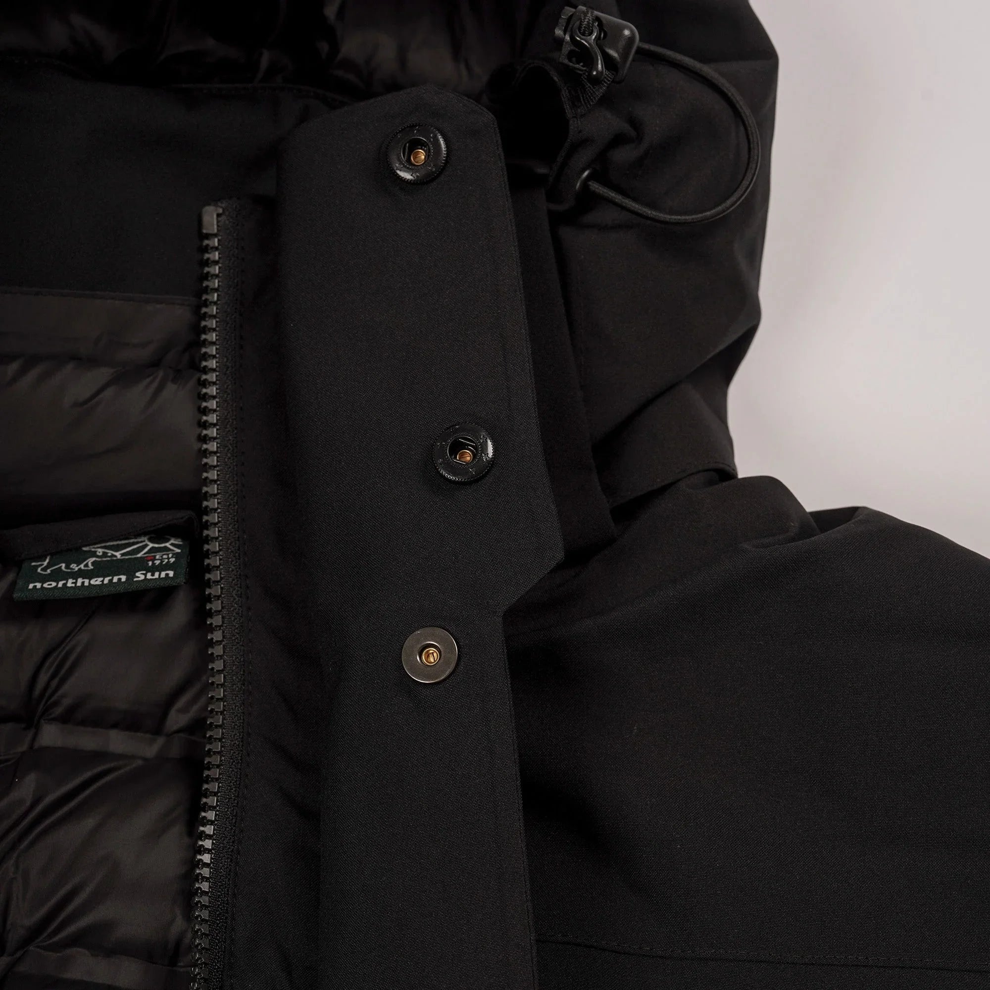 Black Northern Sun puffer jacket with hood, snap buttons, zipper, and logo tag detail