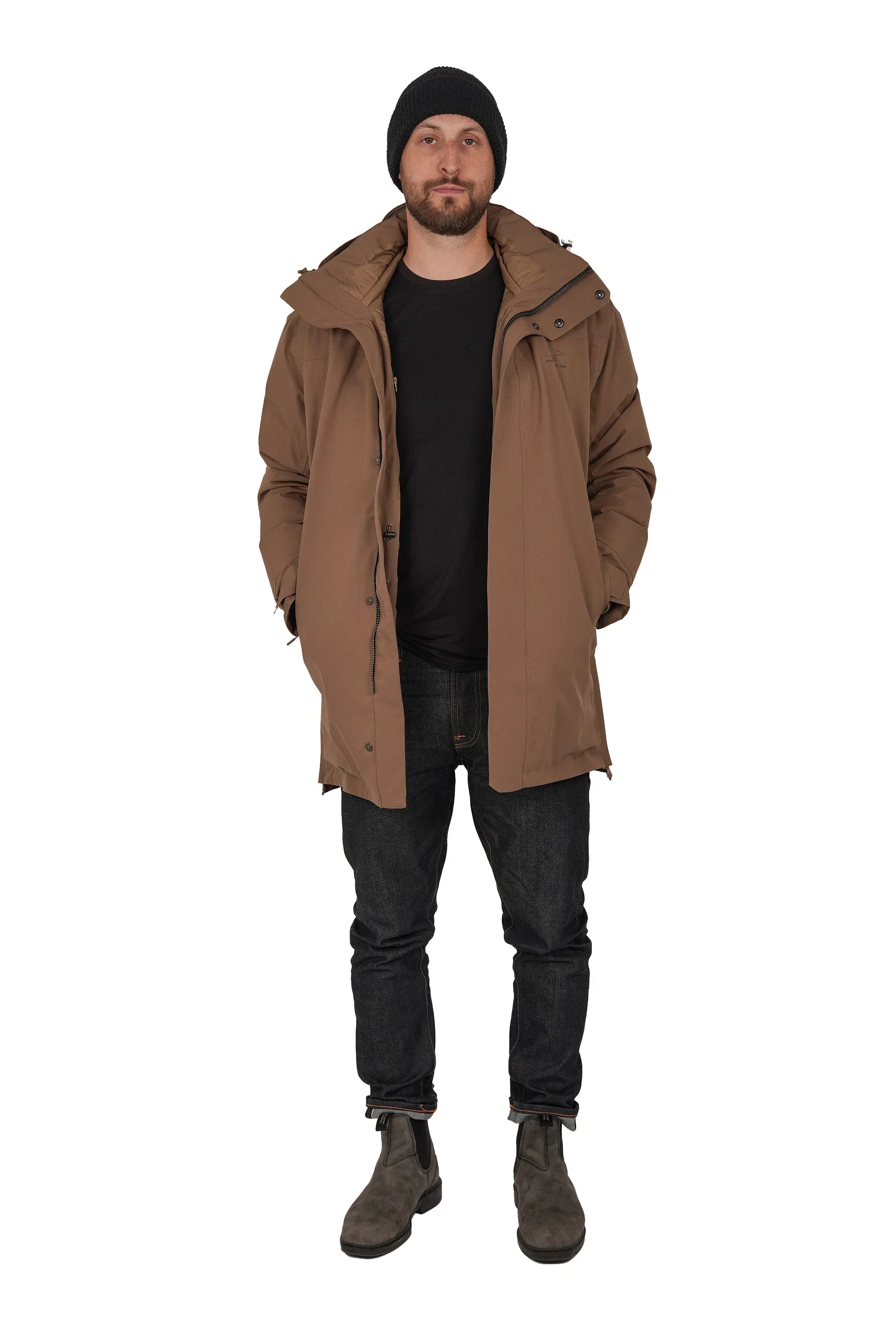 Man wearing brown winter parka, black beanie, jeans and boots on white background