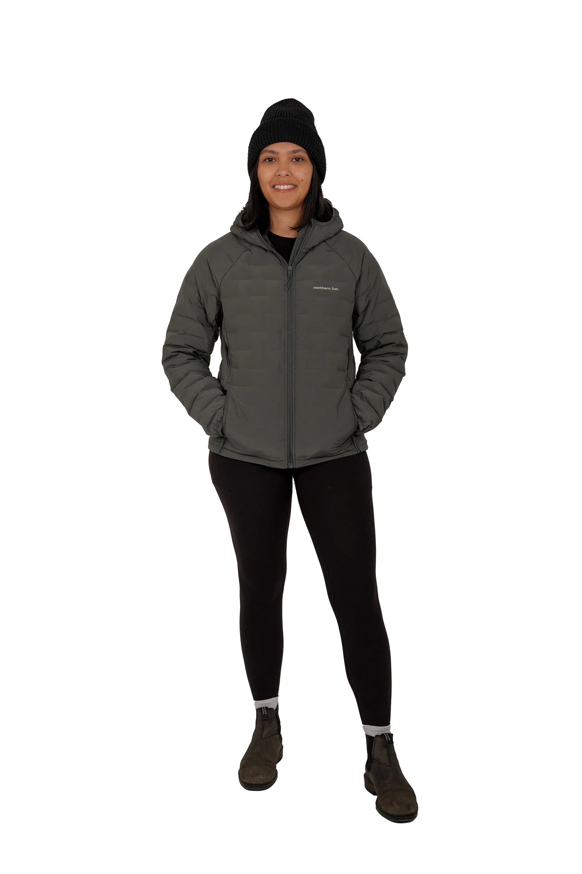 Woman wearing green Northern Sun lightweight down jacket and black beanie, full body front view
