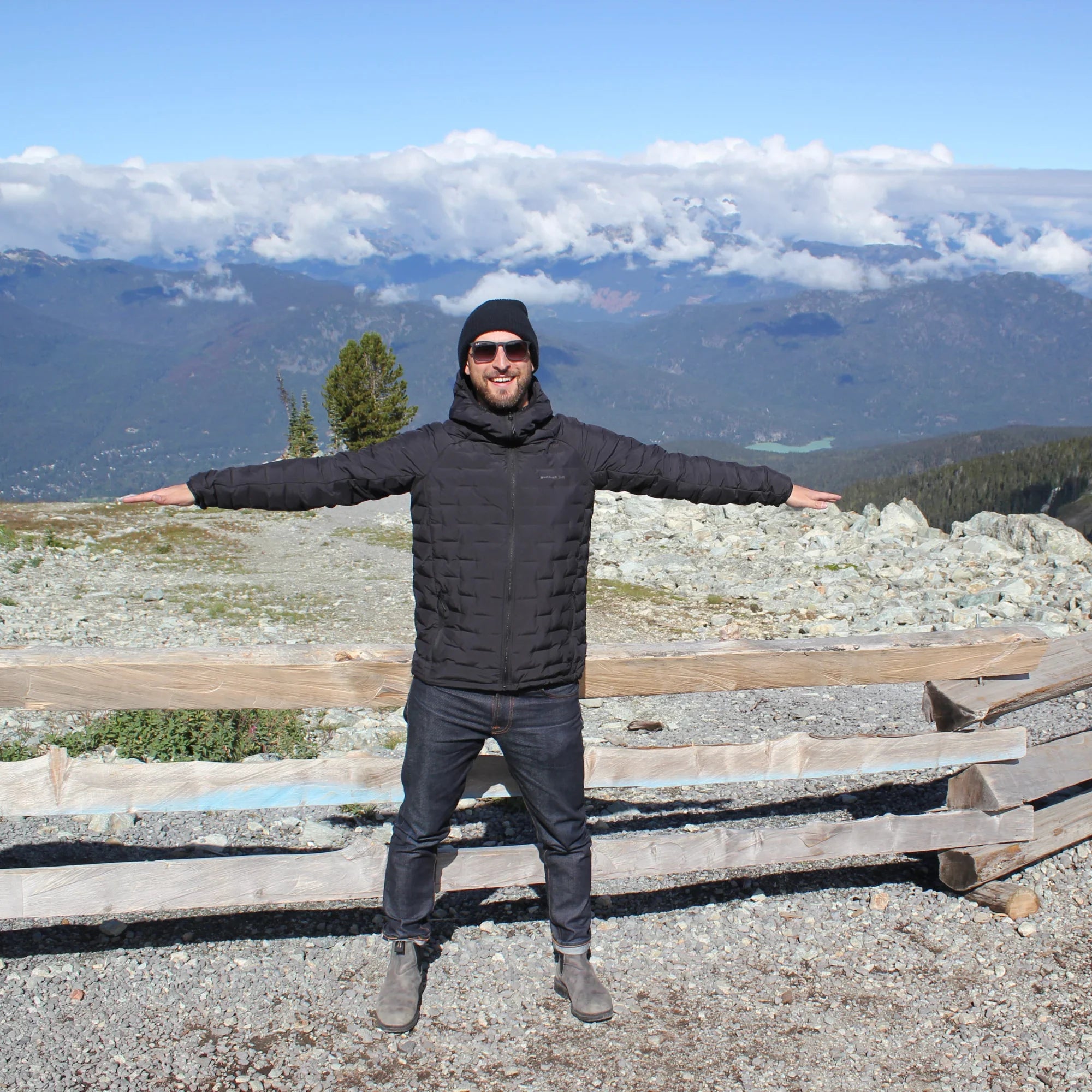 Man wearing a black woven mountain puffer jacket outdoors in winter landscape