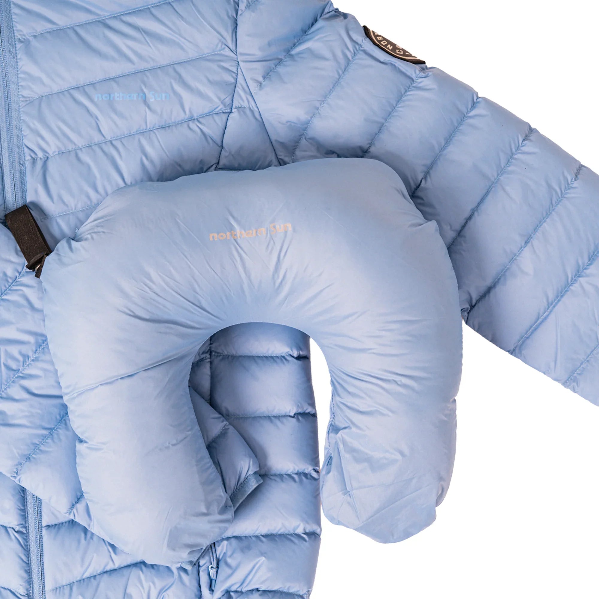 Light blue puffer jacket and matching travel neck pillow by northern sun