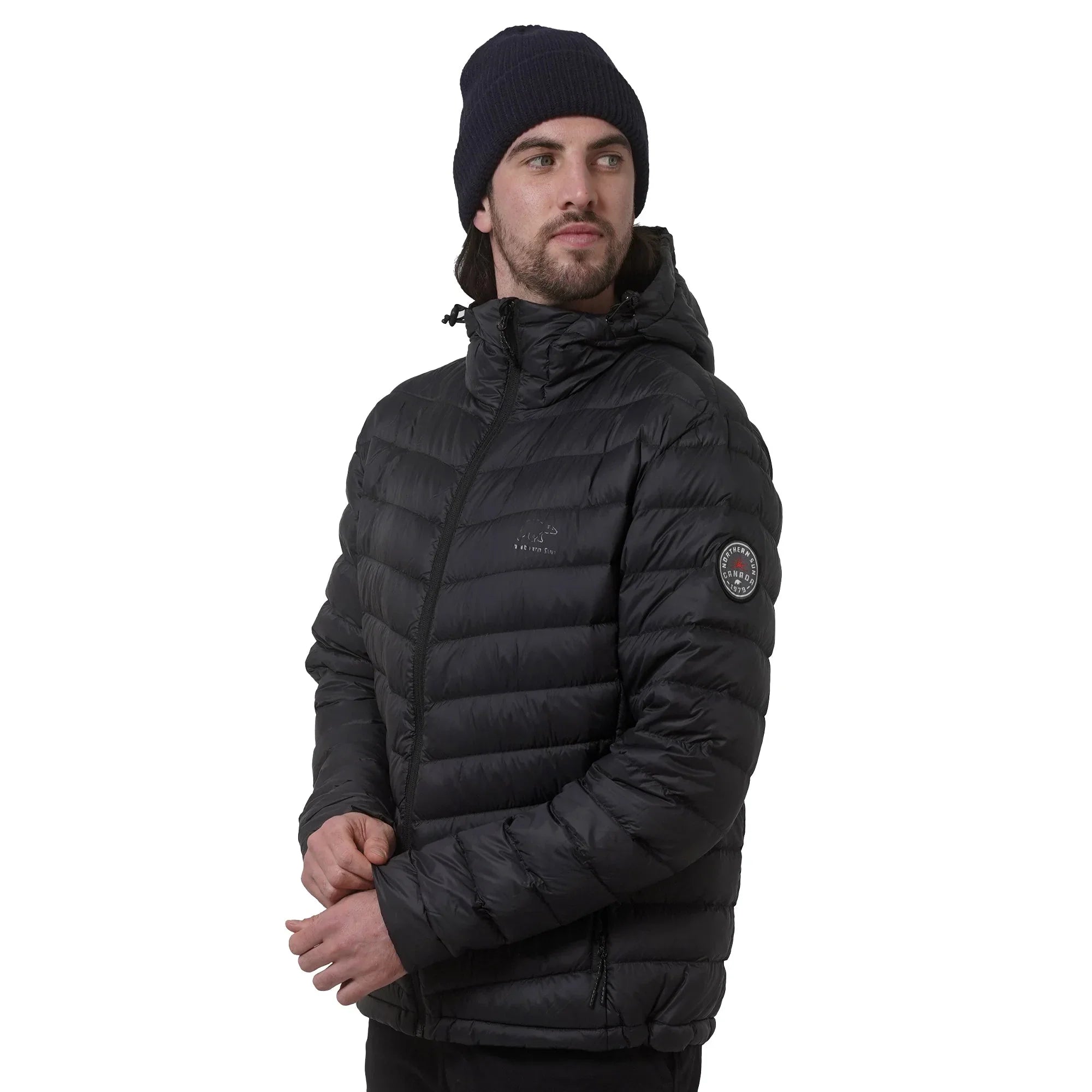 Man in black puffer jacket with hood and navy beanie on white background