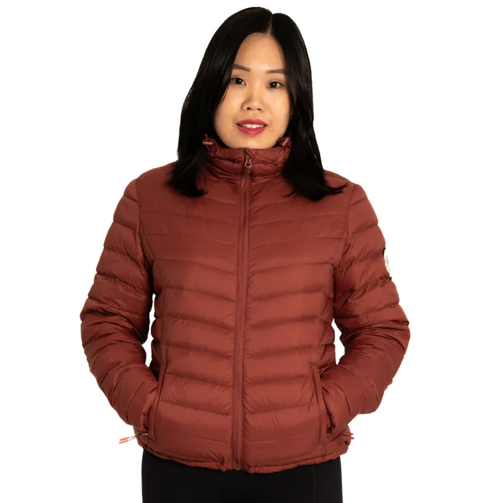 Woman wearing maroon packable puffer jacket with front zipper, hands in pockets