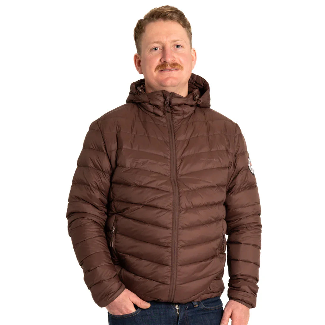 Man wearing brown packable puffer jacket with hood, standing against white background