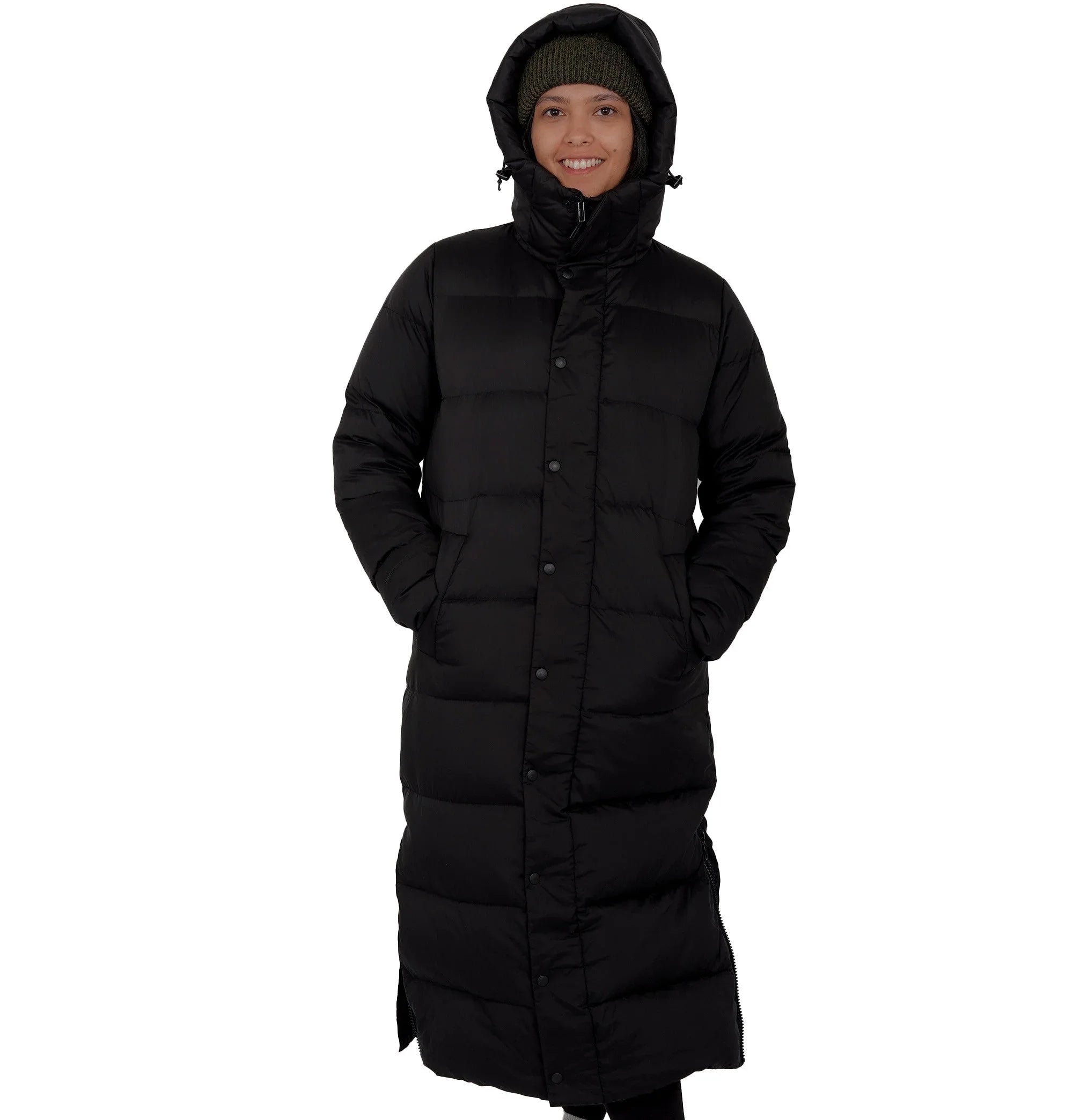 Smiling person wearing long black puffer winter coat with hood and green knit hat