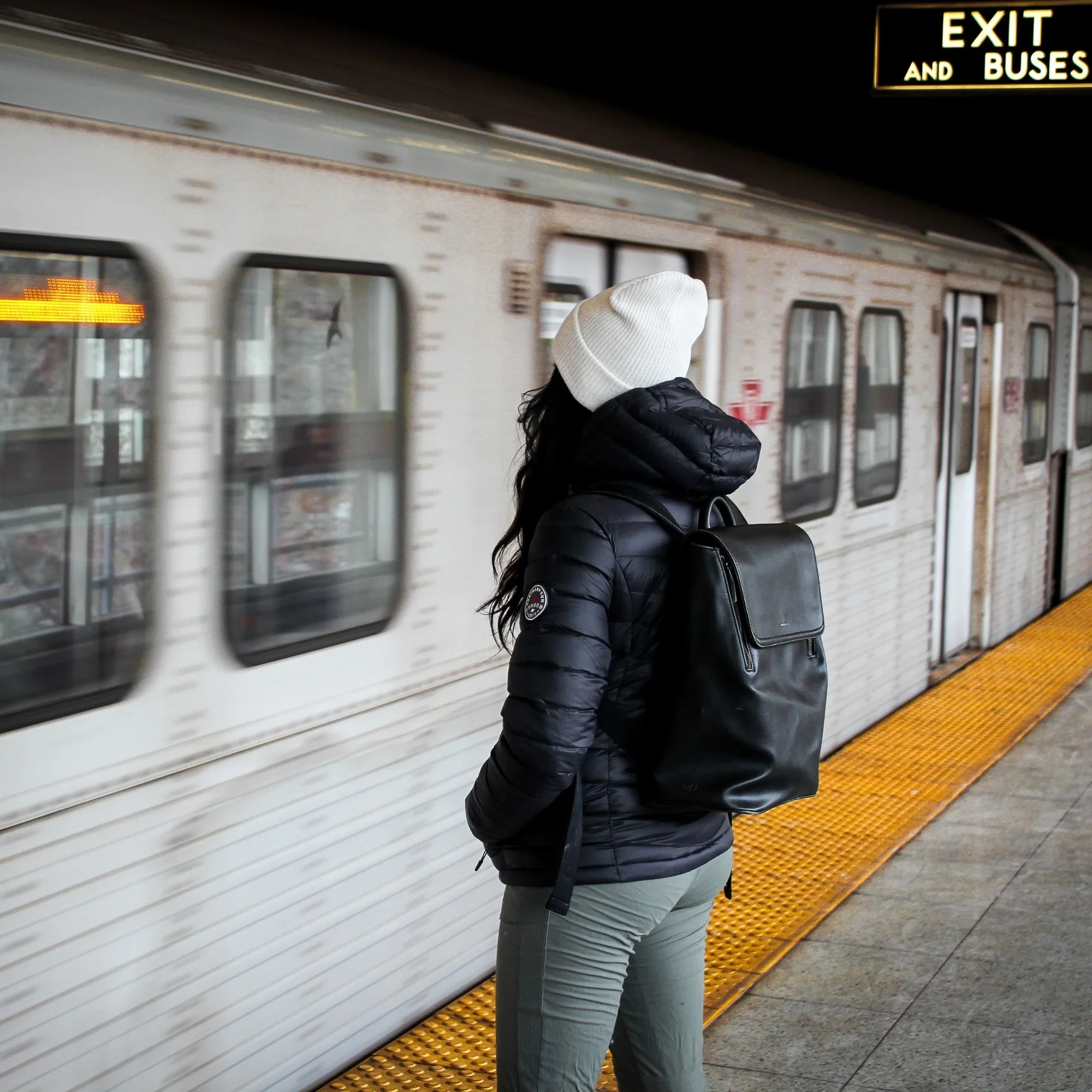 Woman in black packable lightweight down jacket waiting for Toronto subway train
