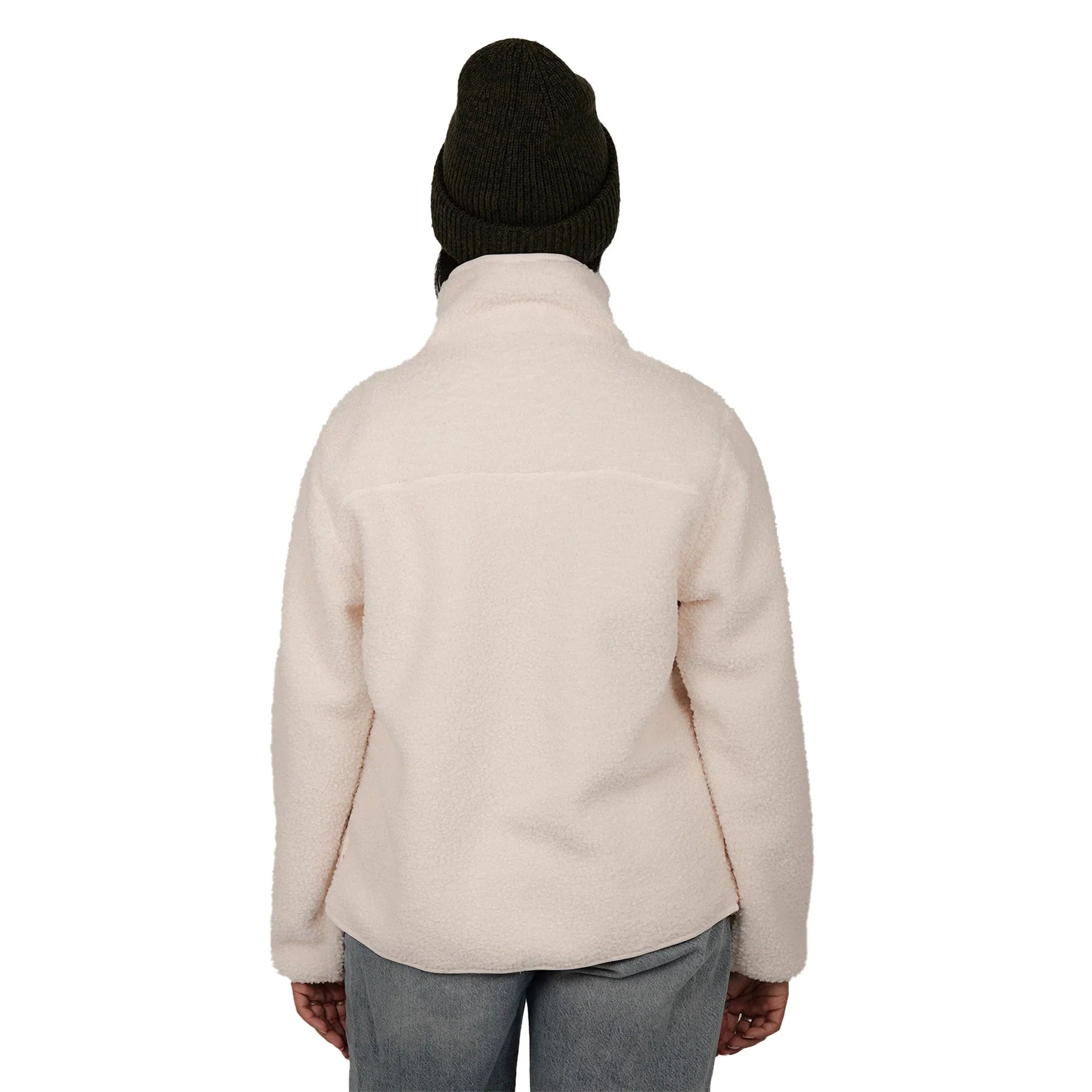 Back view of woman in cream teddy fleece jacket, gray jeans, and dark knit beanie