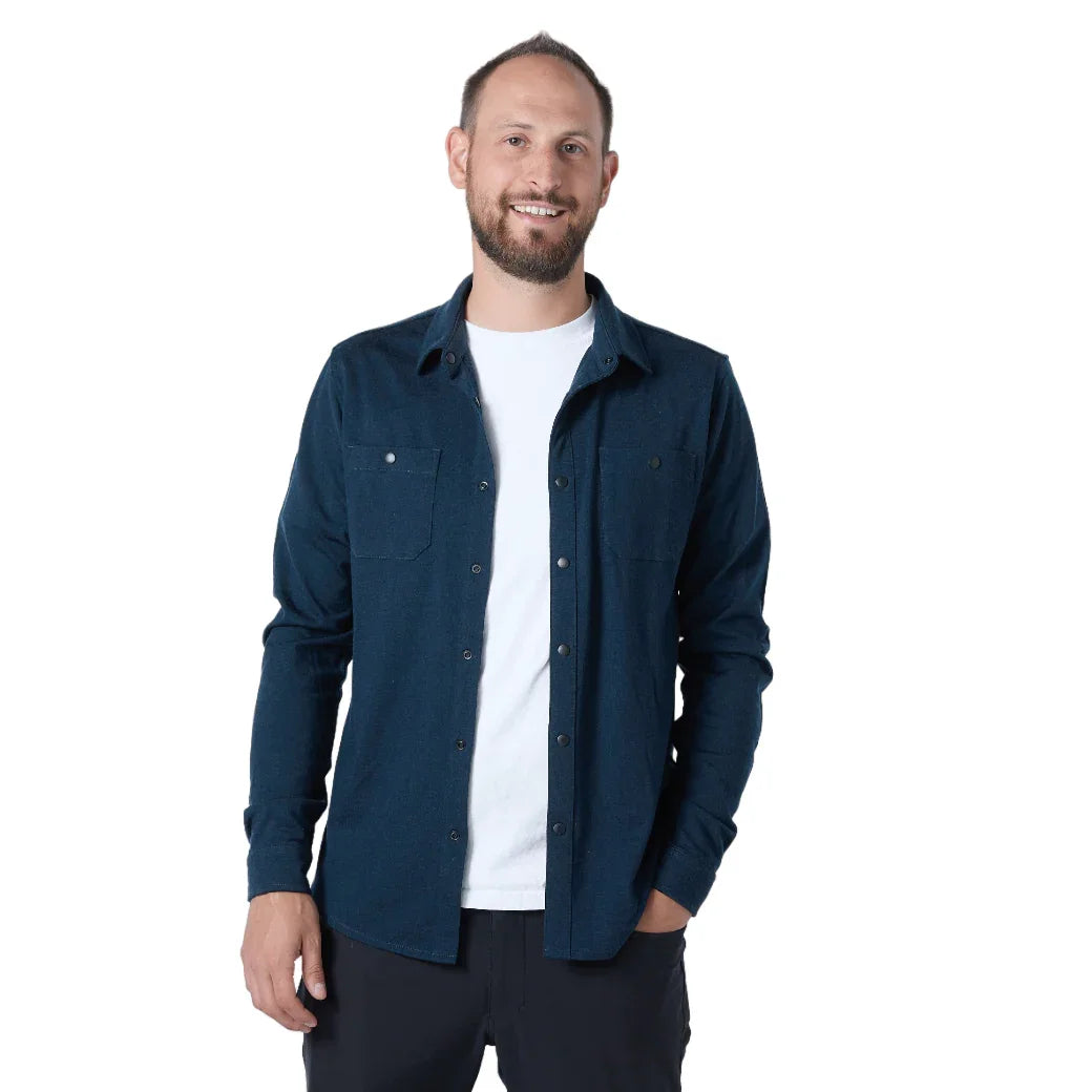 Man wearing navy merino wool shacket unbuttoned over white shirt, front view