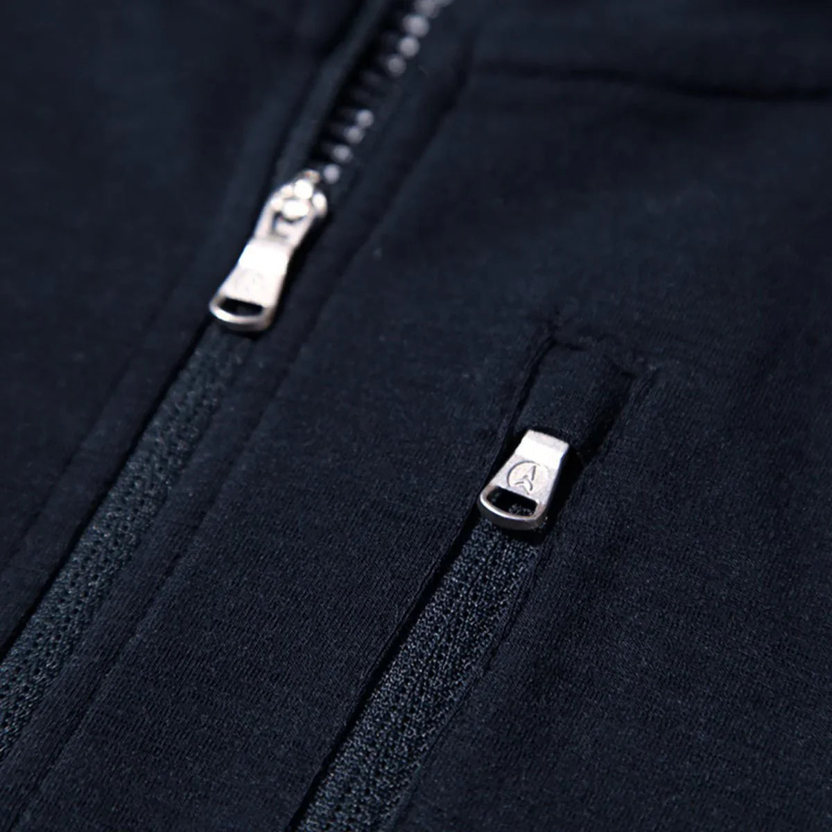 Close-up of black merino wool hoodie with two visible zippers and soft fabric texture