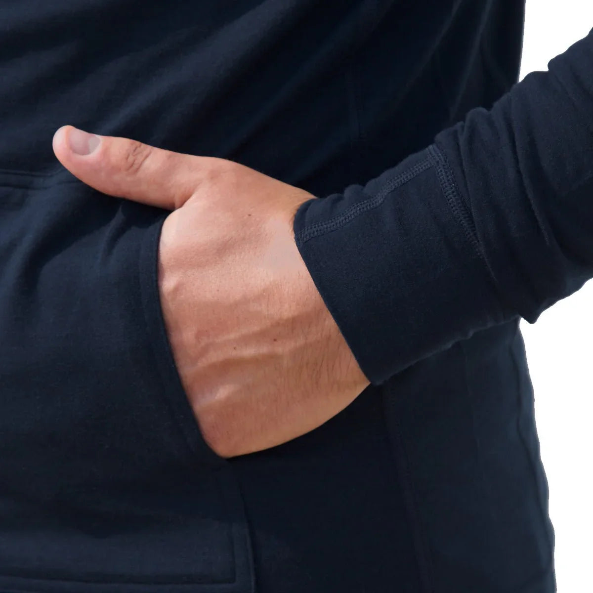 Close-up of hand in pocket of black men's merino wool midlayer hoodie