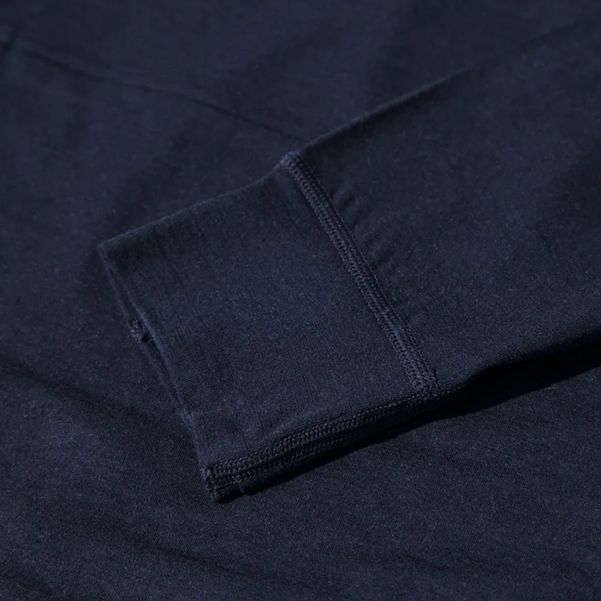 Close-up of navy merino wool hoodie cuff, showcasing soft midlayer fabric texture