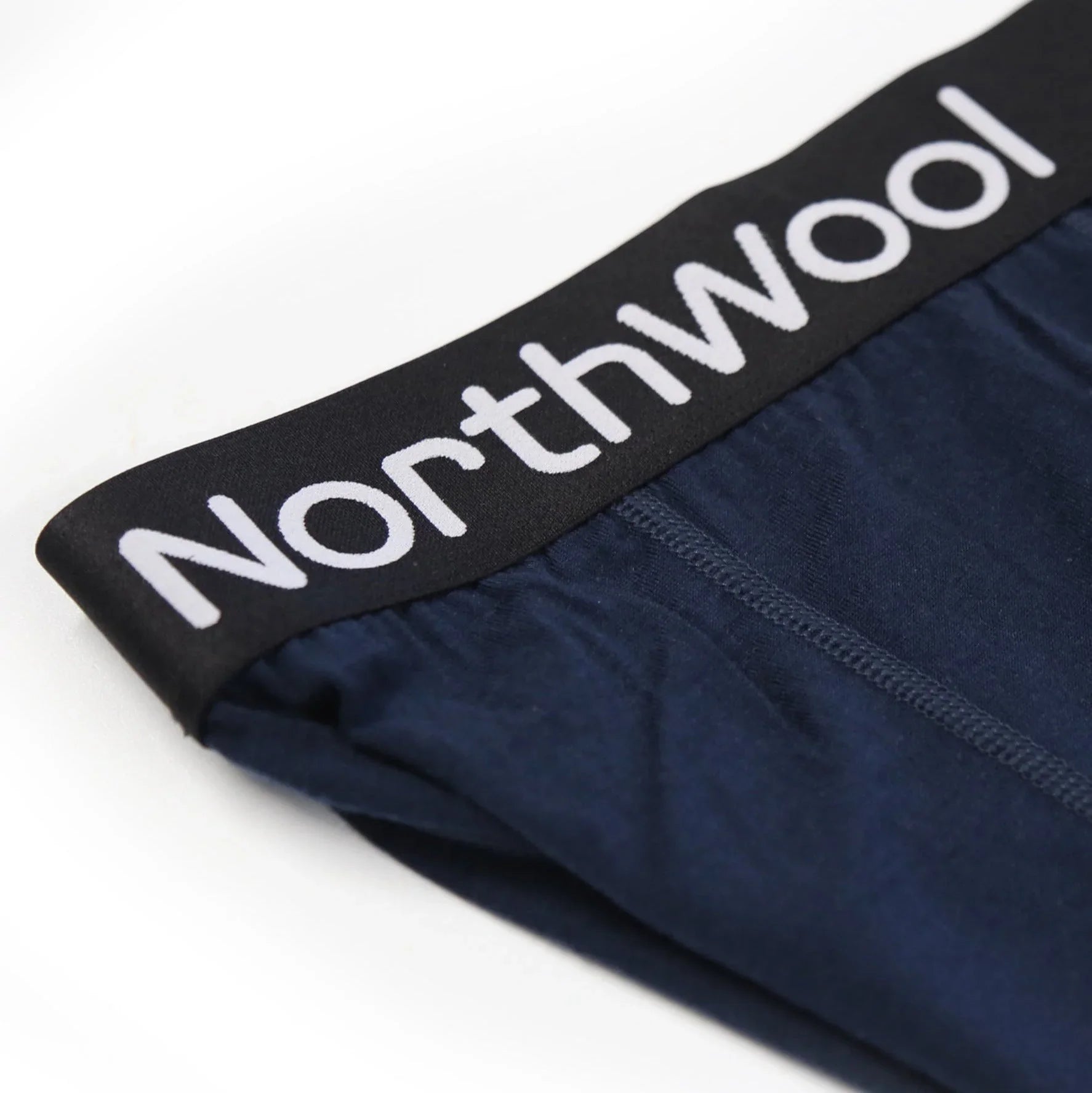 NorthWool black waistband on navy blue men's underwear, close-up view.