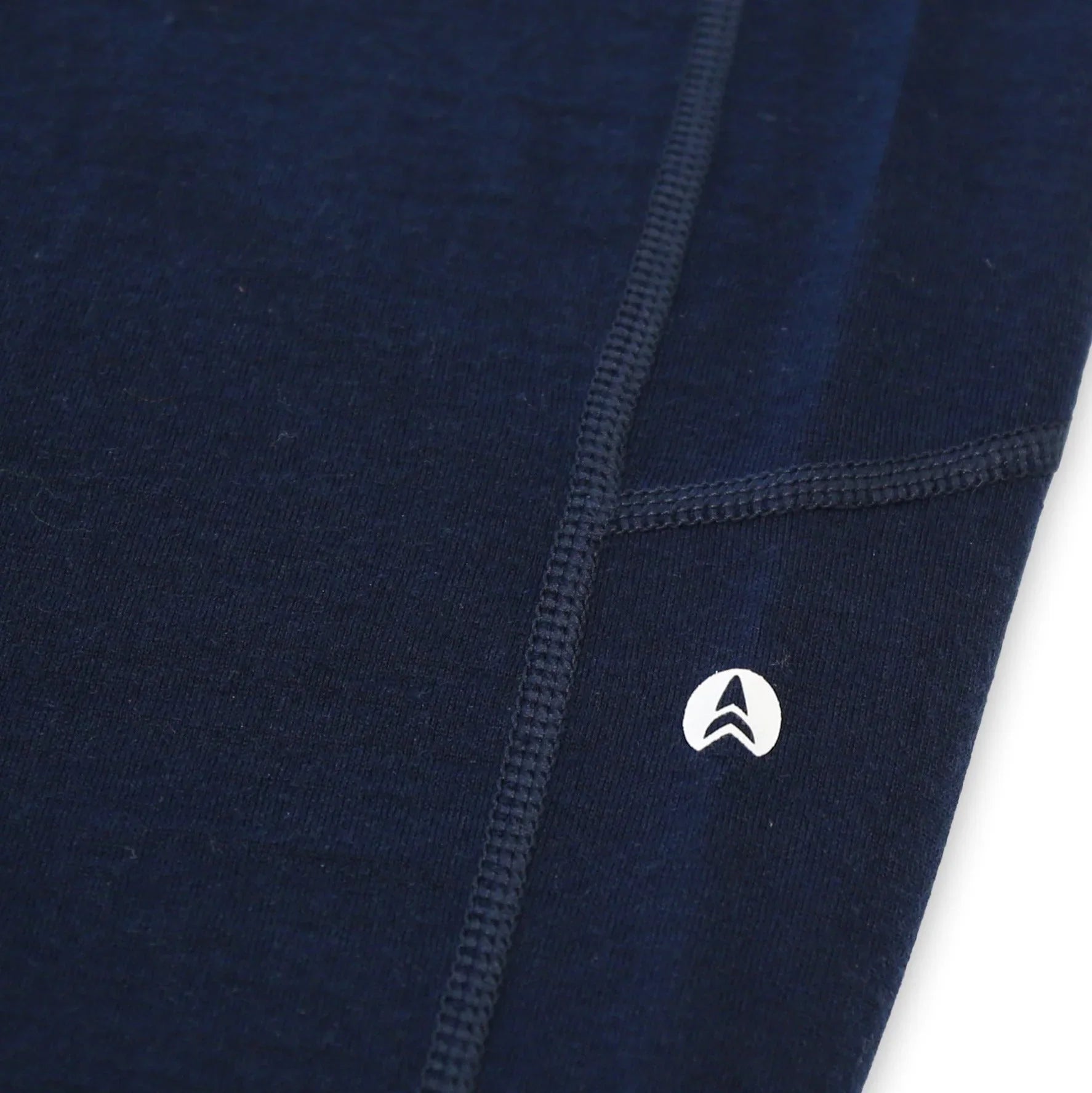 Navy blue seamless activewear fabric closeup with visible stitching and small white logo
