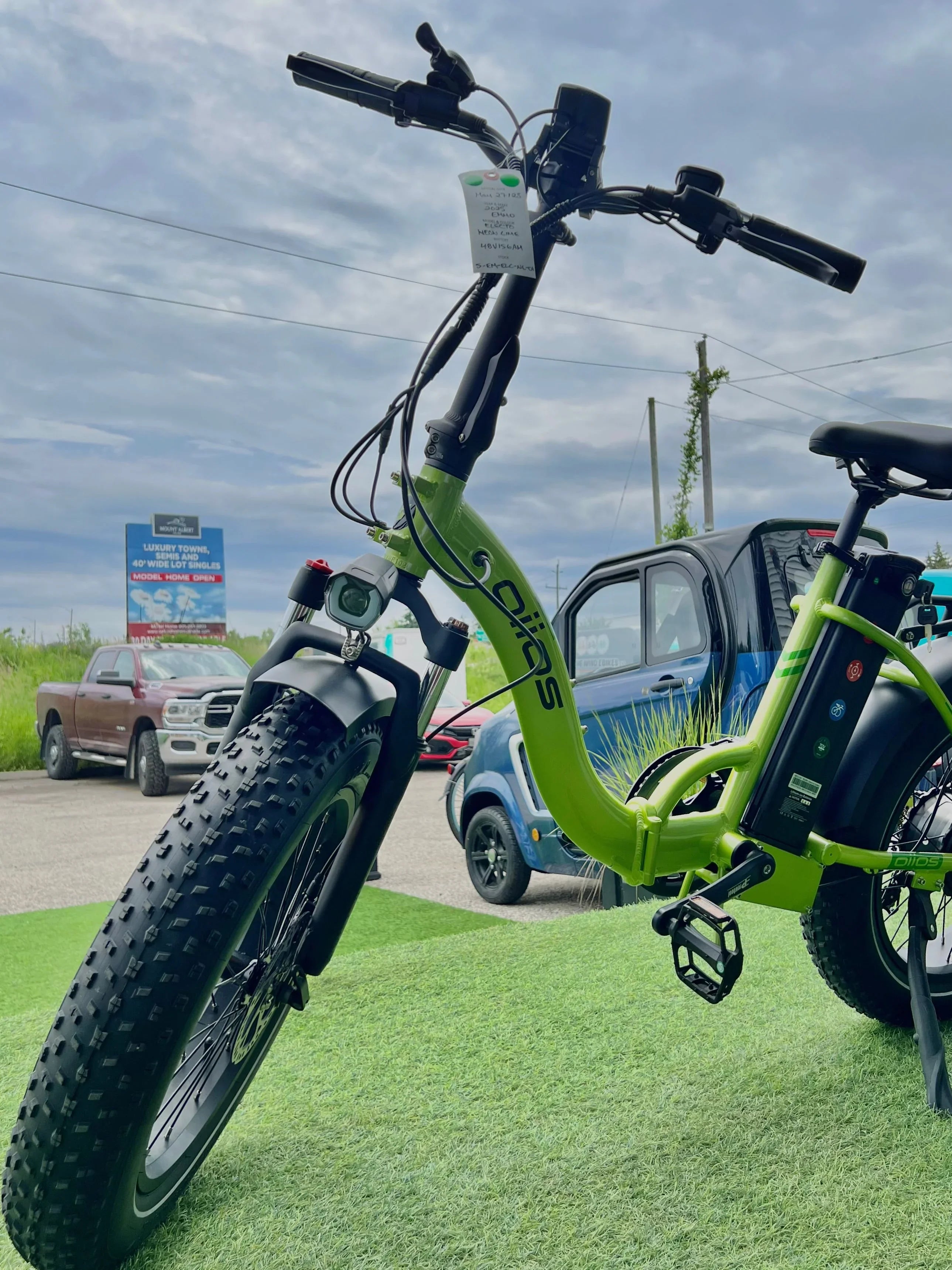 Green SOLOS electric bike with fat tires displayed outdoors on artificial grass