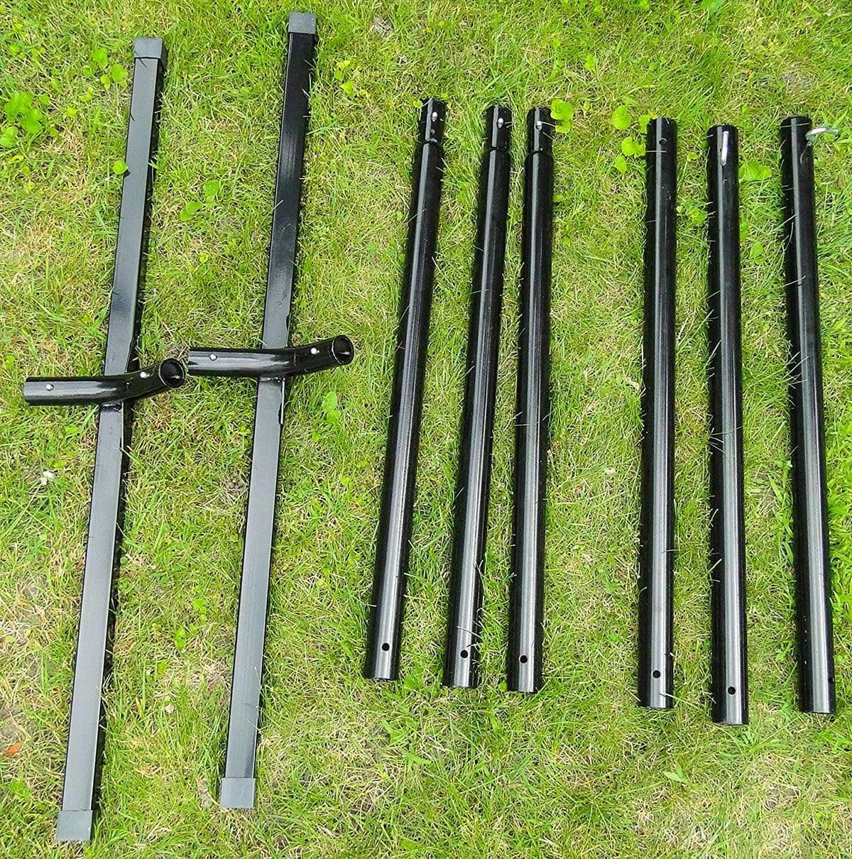 Black metal hammock stand parts laid out on green grass for easy assembly