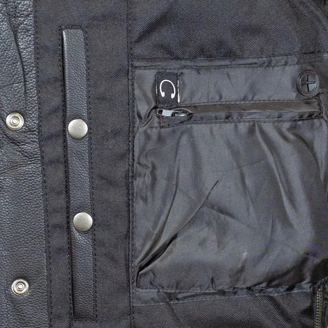 Close-up of black men's leather vest interior pocket with snap buttons and zipper.