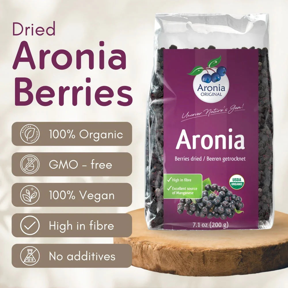 Bag of dried Aronia berries on wood, labeled organic, vegan, high fiber, GMO-free, no additives