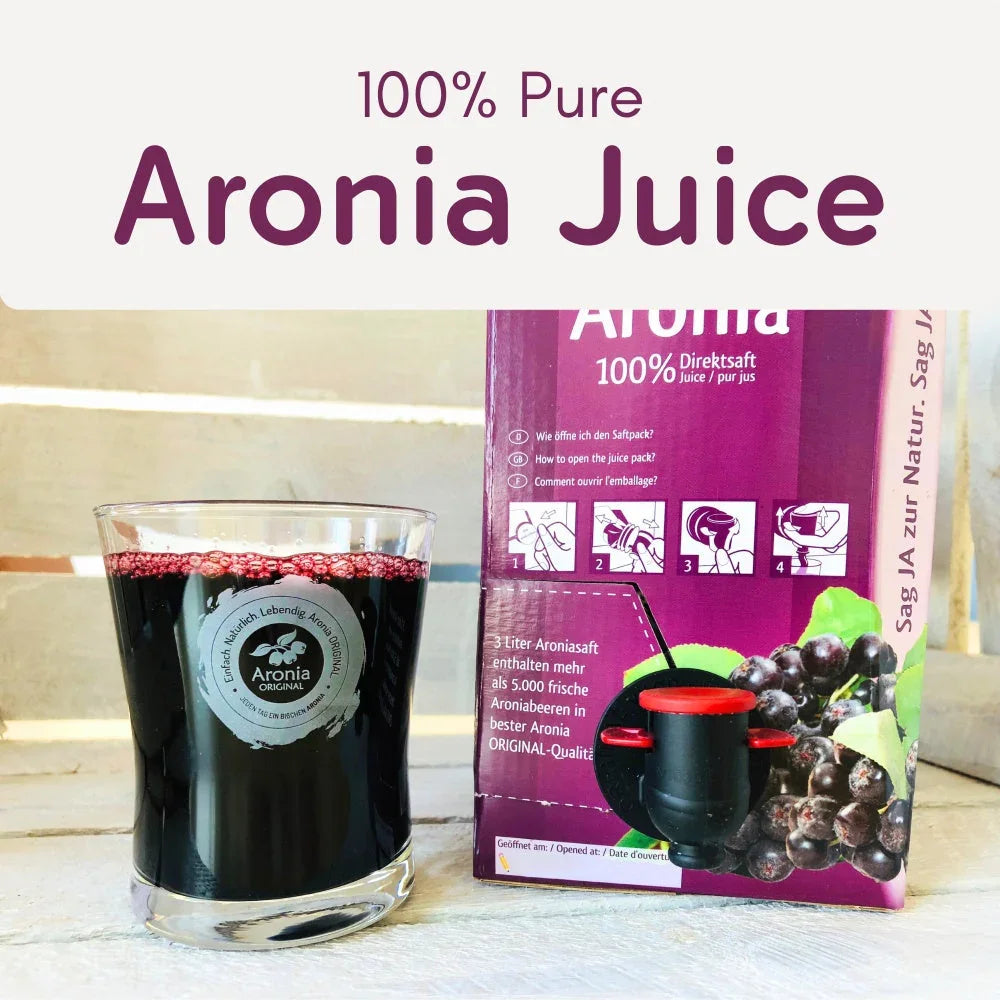 Glass of Aronia juice beside 3-liter box with berries and dispensing spout