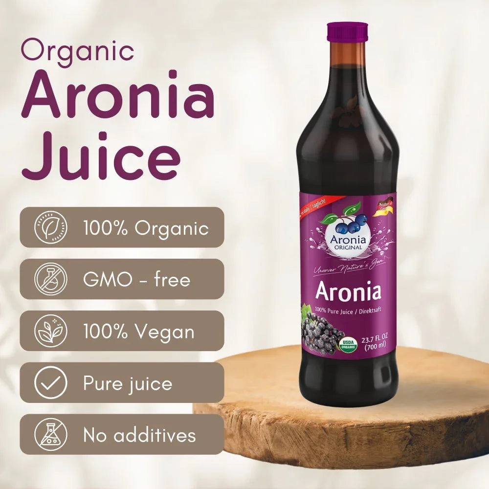 Glass bottle of organic Aronia juice with vegan, non-GMO, pure juice label on wooden surface