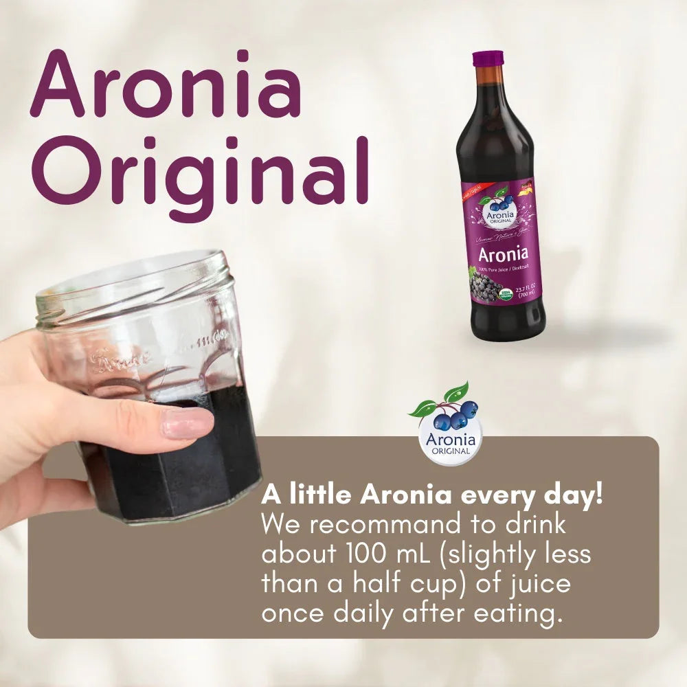 Hand holding a glass of Aronia juice with an Aronia Original juice bottle and product info.