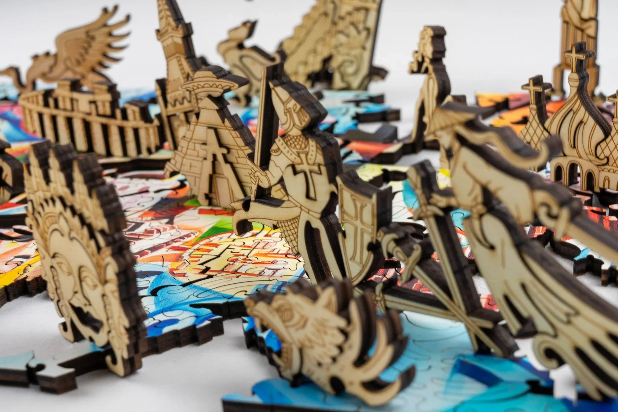Laser-cut wooden puzzle pieces with historical and mythical figures on a colorful board