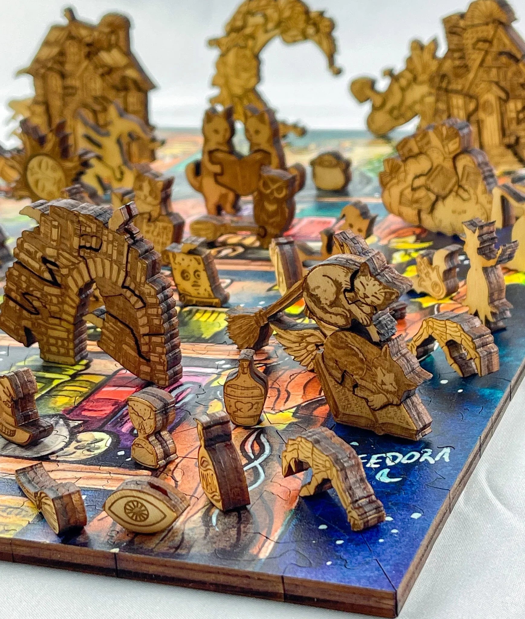 Wooden 3D puzzle with cats, archways, and fantasy figures on a colorful board game