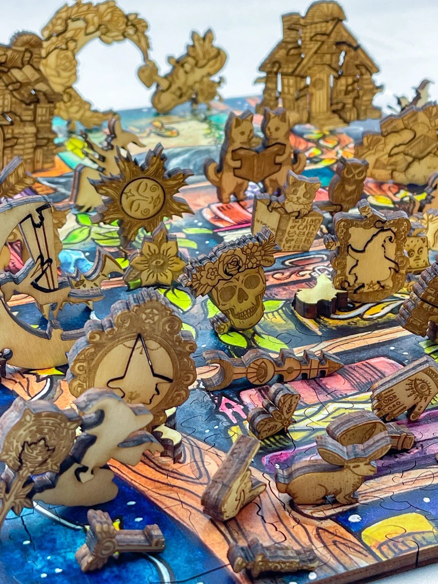 Colorful wooden jigsaw puzzle with whimsical pieces, including cats, sun, skull, and houses