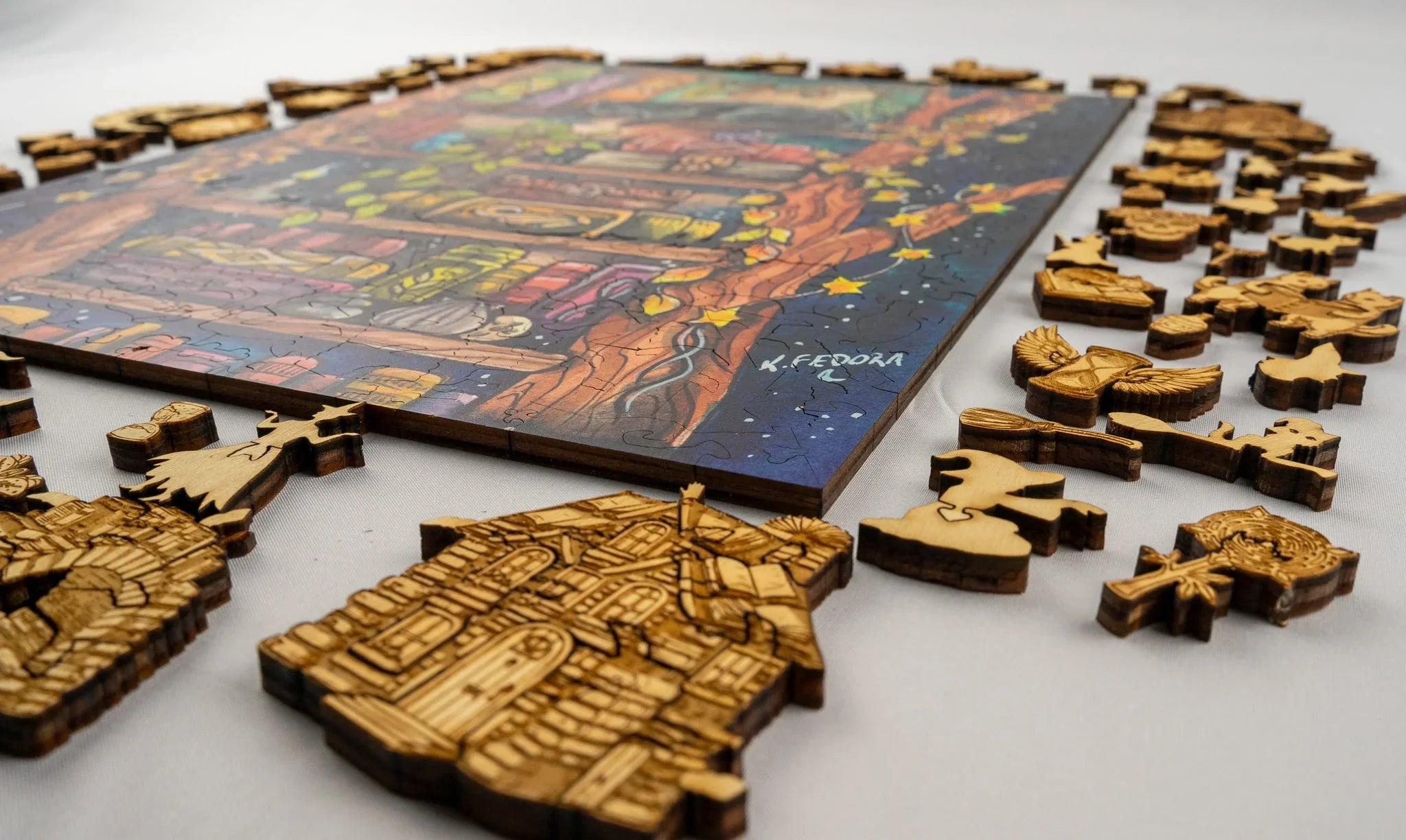 Wooden jigsaw puzzle with colorful fantasy artwork and unique shaped pieces on white surface