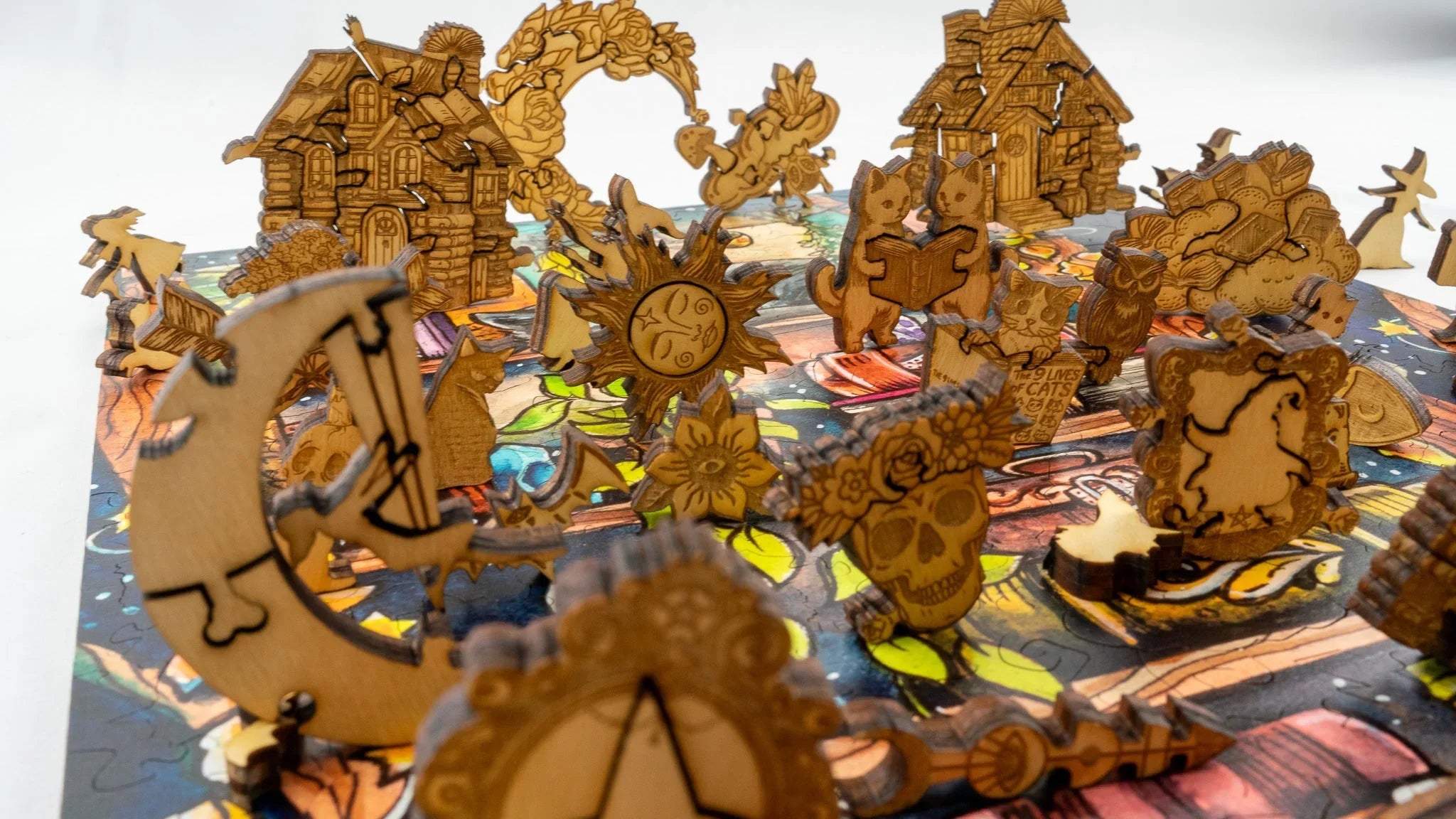 Wooden whimsical cat puzzle pieces with houses, moon, sun, and fantasy shapes assembled.
