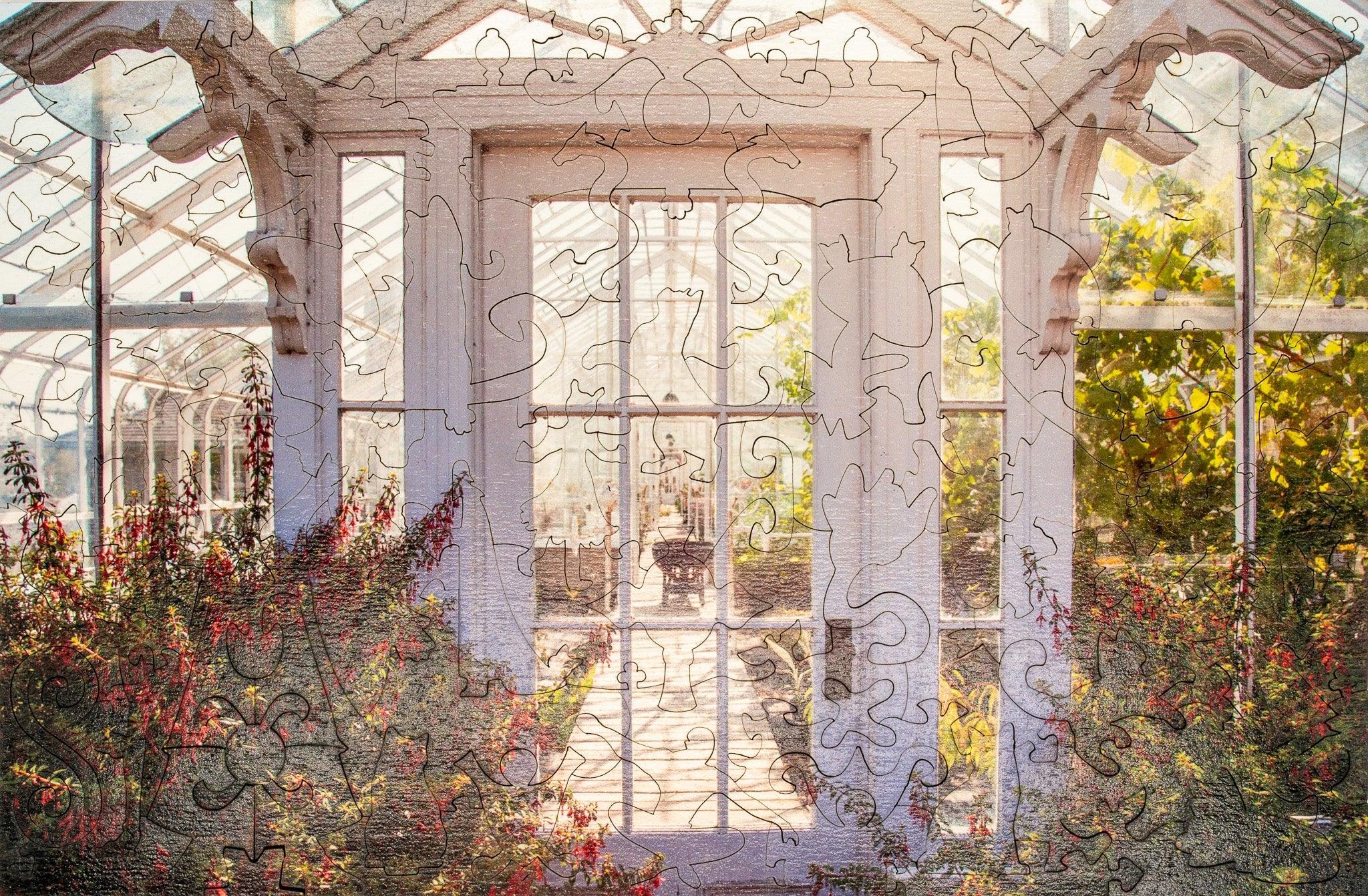 Wooden jigsaw puzzle showing a sunlit greenhouse with flowers and glass windows