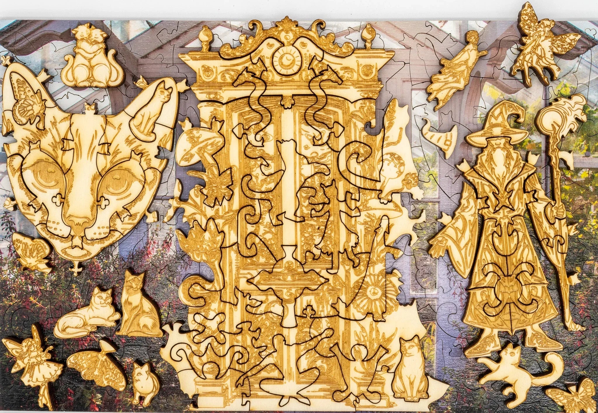 Wooden puzzle pieces shaped like a wizard, cats, fairies, and ornate designs on floral background