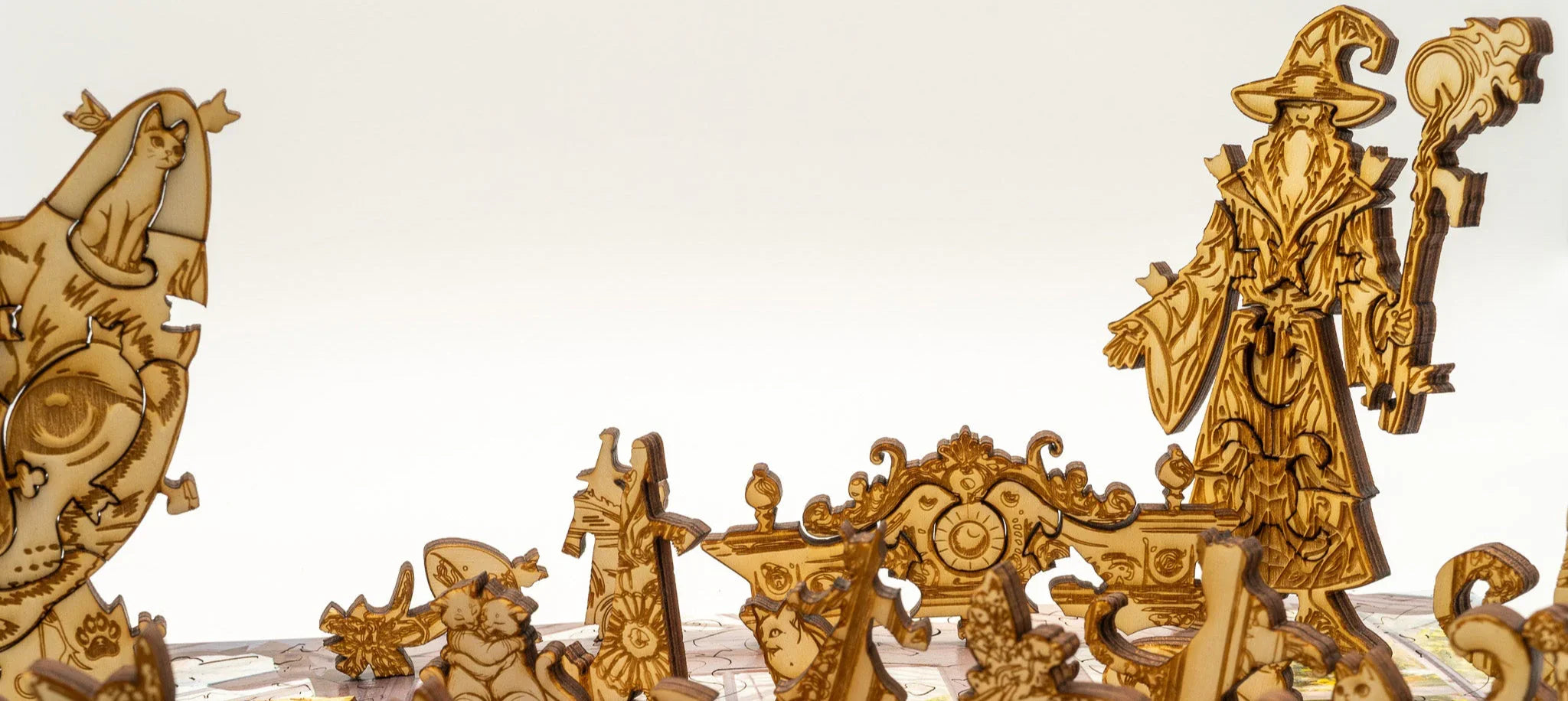 Wooden wizard puzzle pieces with engraved fantasy cat and magic details on white background