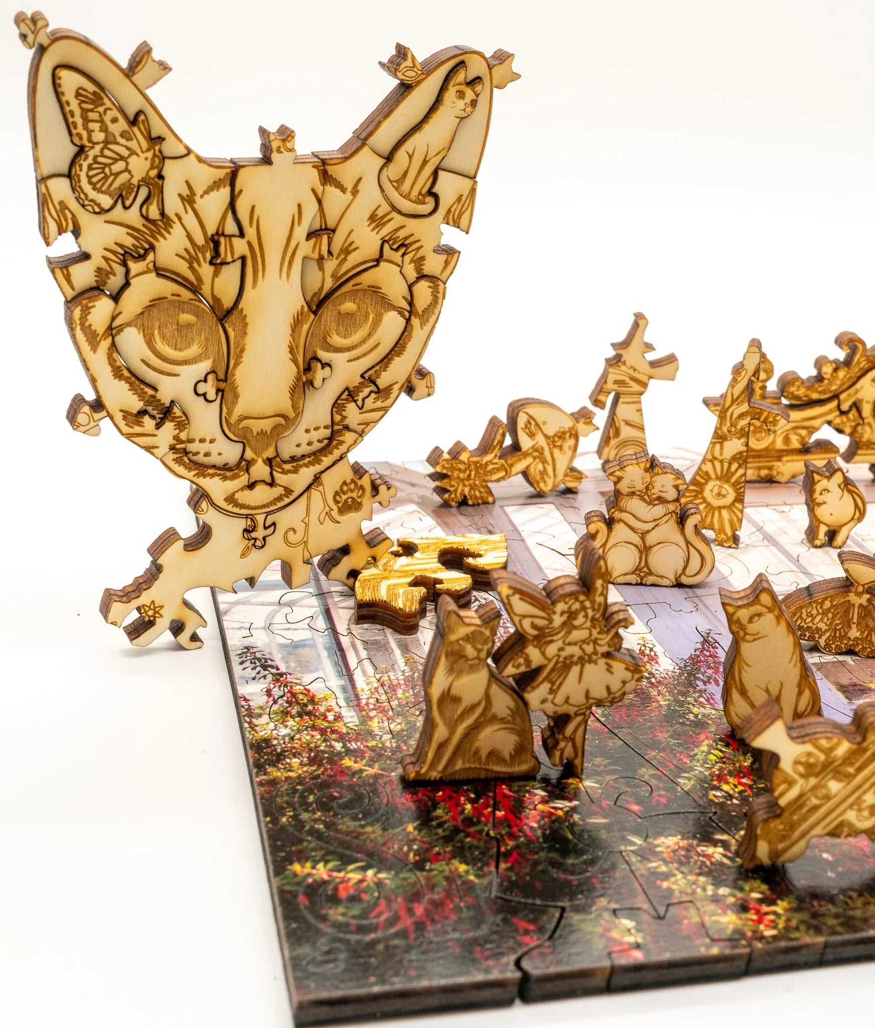 Wooden cat-shaped puzzle pieces with detailed engravings on a colorful puzzle board