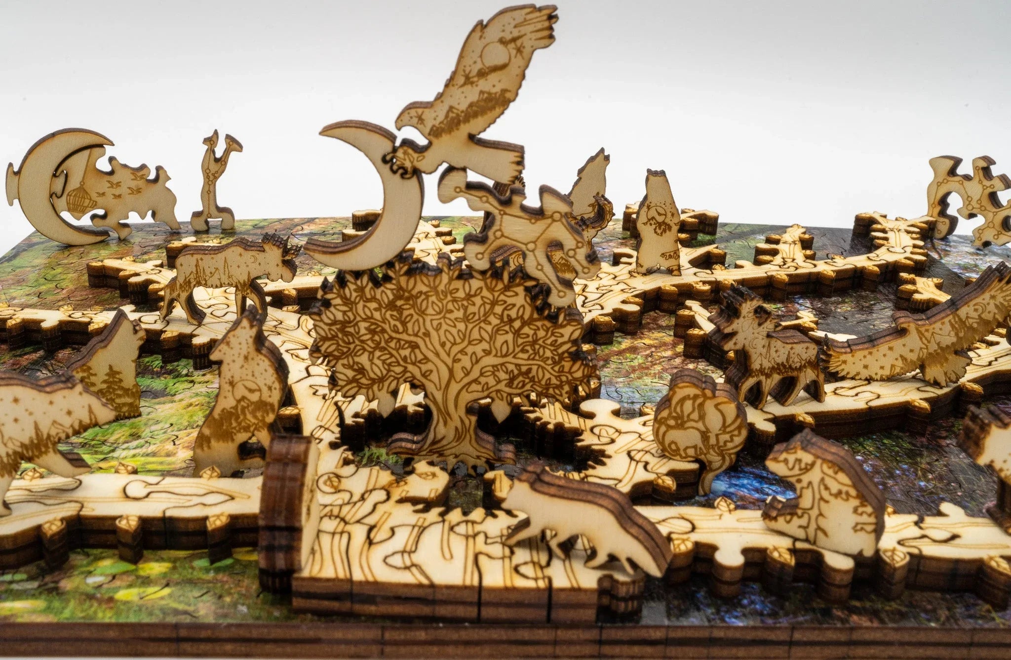 Laser-cut wooden animal and tree puzzle pieces assembled on a colorful puzzle board