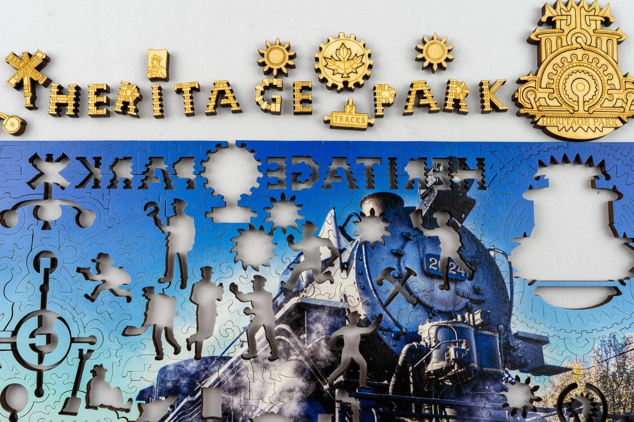 Heritage Park puzzle pieces with train theme and cut-out worker silhouettes on a blue steam locomotive